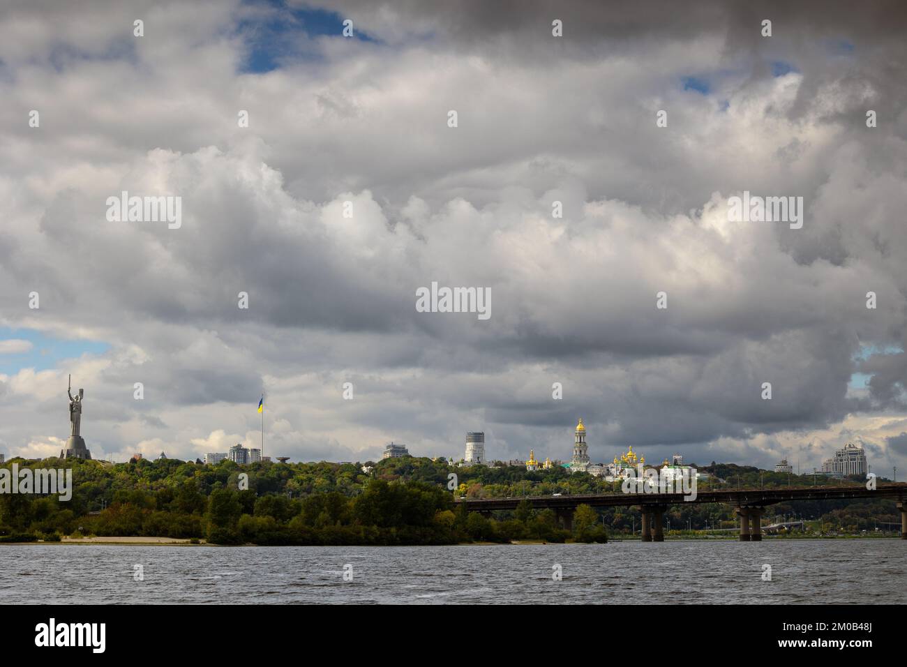 Vista della grande città sulle colline sopra il fiume in un tramonto fantastico e luminoso. Vista alla Riserva Nazionale di Lavra di Kyiv-Pechersk, monumento la Madre di Mothe Foto Stock