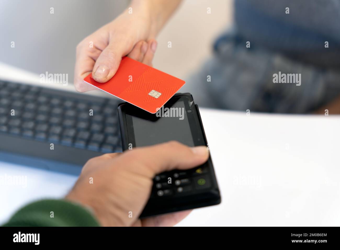 Dall'alto del raccolto irriconoscibile cliente femmina che utilizza la carta di credito mentre paga per l'acquisto contactless al cassiere maschio con terminale Foto Stock