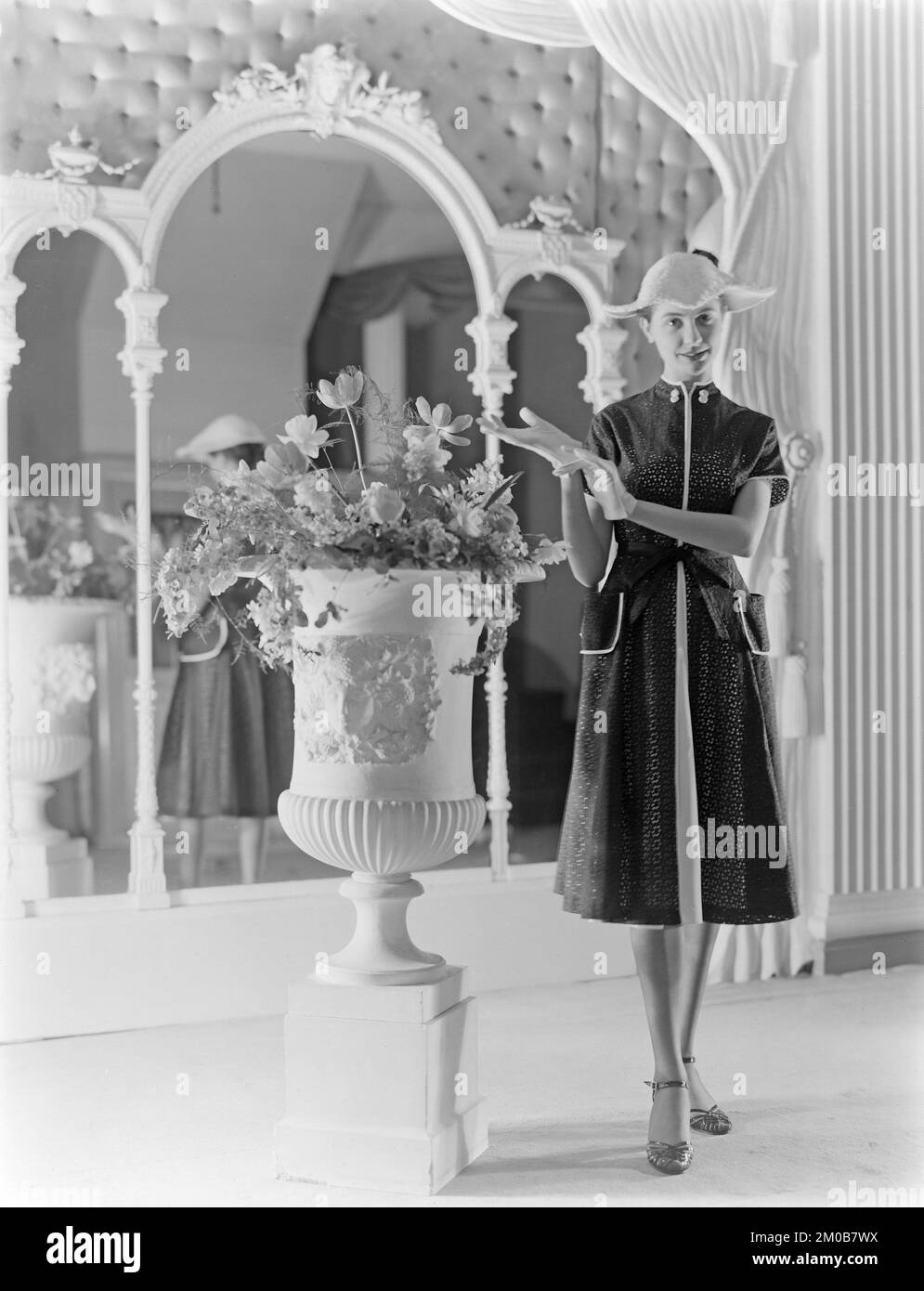 Un modello che lavora per l'Alexandrine Fashion and Model House a Nottingham, Inghilterra, durante gli anni '1950s. Sta posando in uno studio, portando uno dei più recenti disegni di Alexadrine. Foto Stock