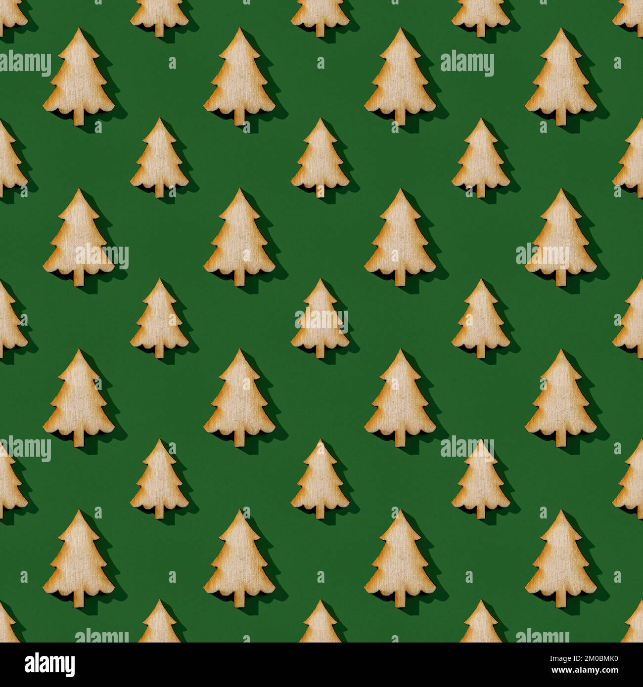 Grandi e piccole silhouette di abete in legno su sfondo verde. Natale e Capodanno modello senza cuciture. Elemento di design per le vacanze invernali. Foto Stock