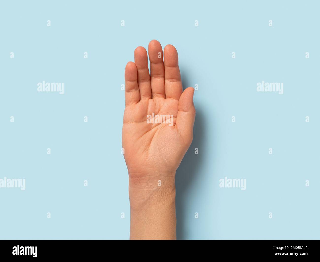 Palma vuota di donna caucasica su sfondo blu pastello. Aprire il movimento della mano in primo piano. Donna adulta macro mano destra. Concetto di parti della carrozzeria. Foto Stock