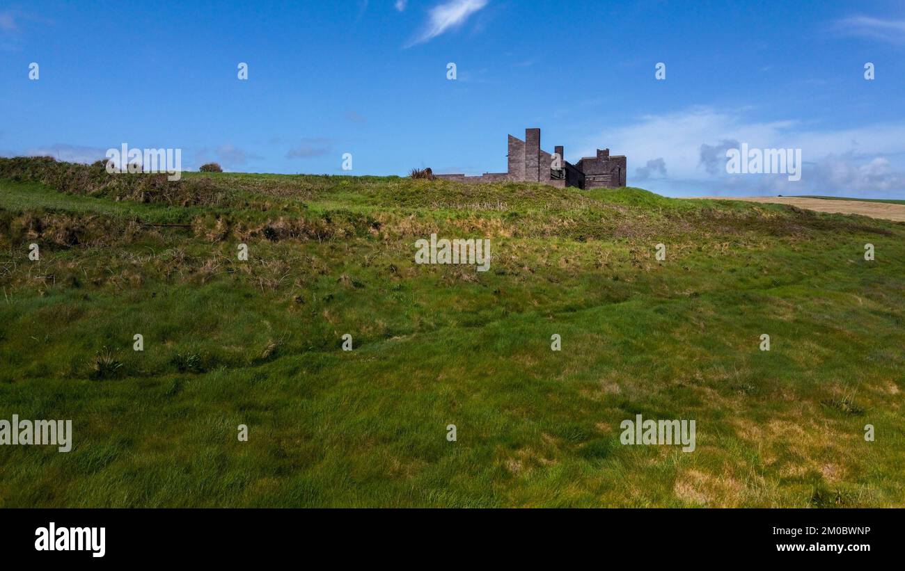 Un vecchio edificio incompiuto su una collina verde. Bel cielo con nuvole. Foto aerea. Foto Stock