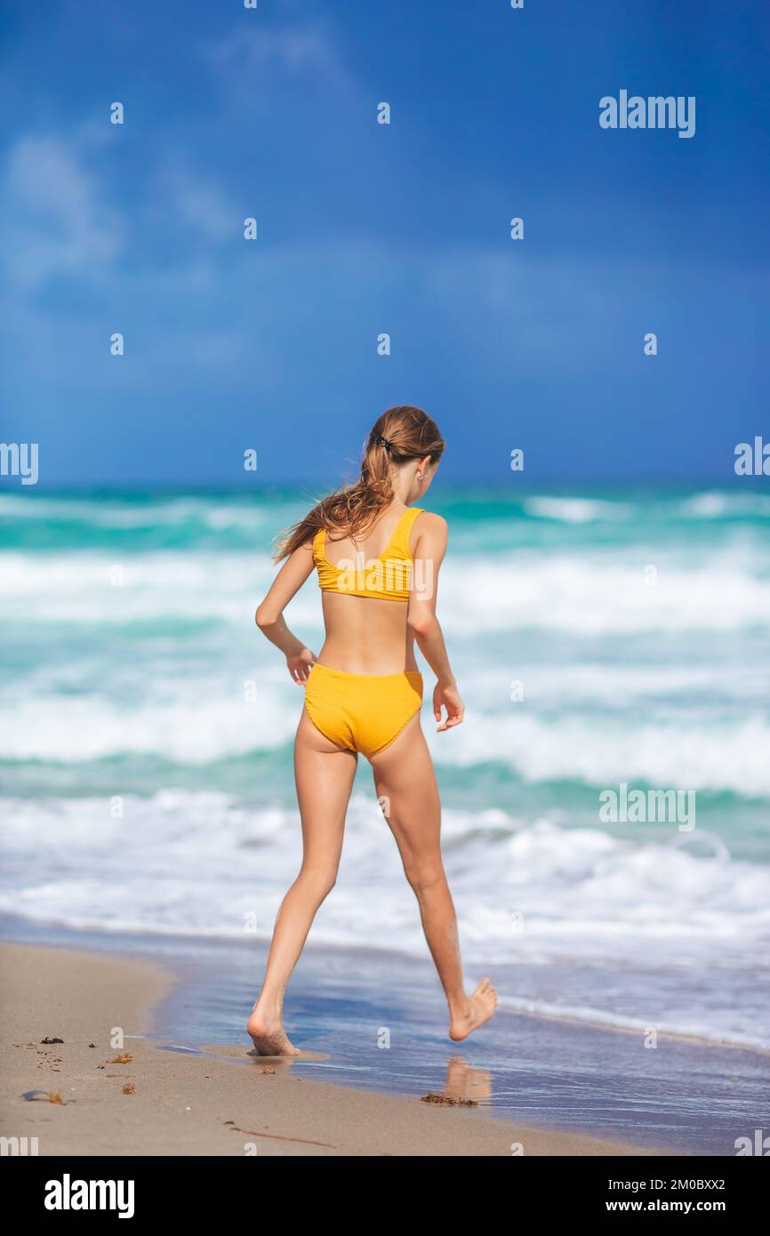 Adorabile ragazza divertirsi sulla spiaggia tropicale durante le vacanze Foto Stock