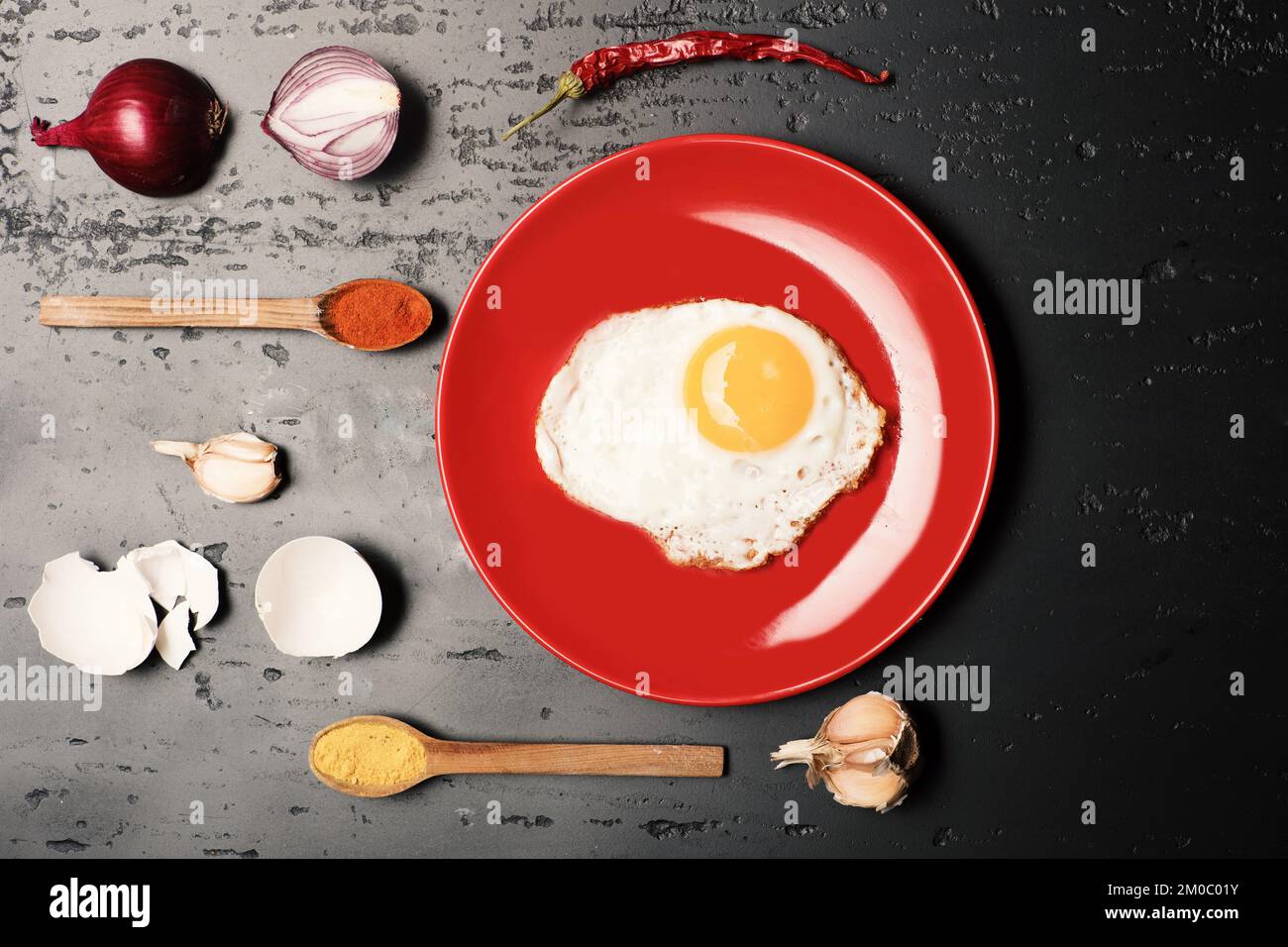 Cibo messo su piatto rosso su sfondo scuro. Foto Stock