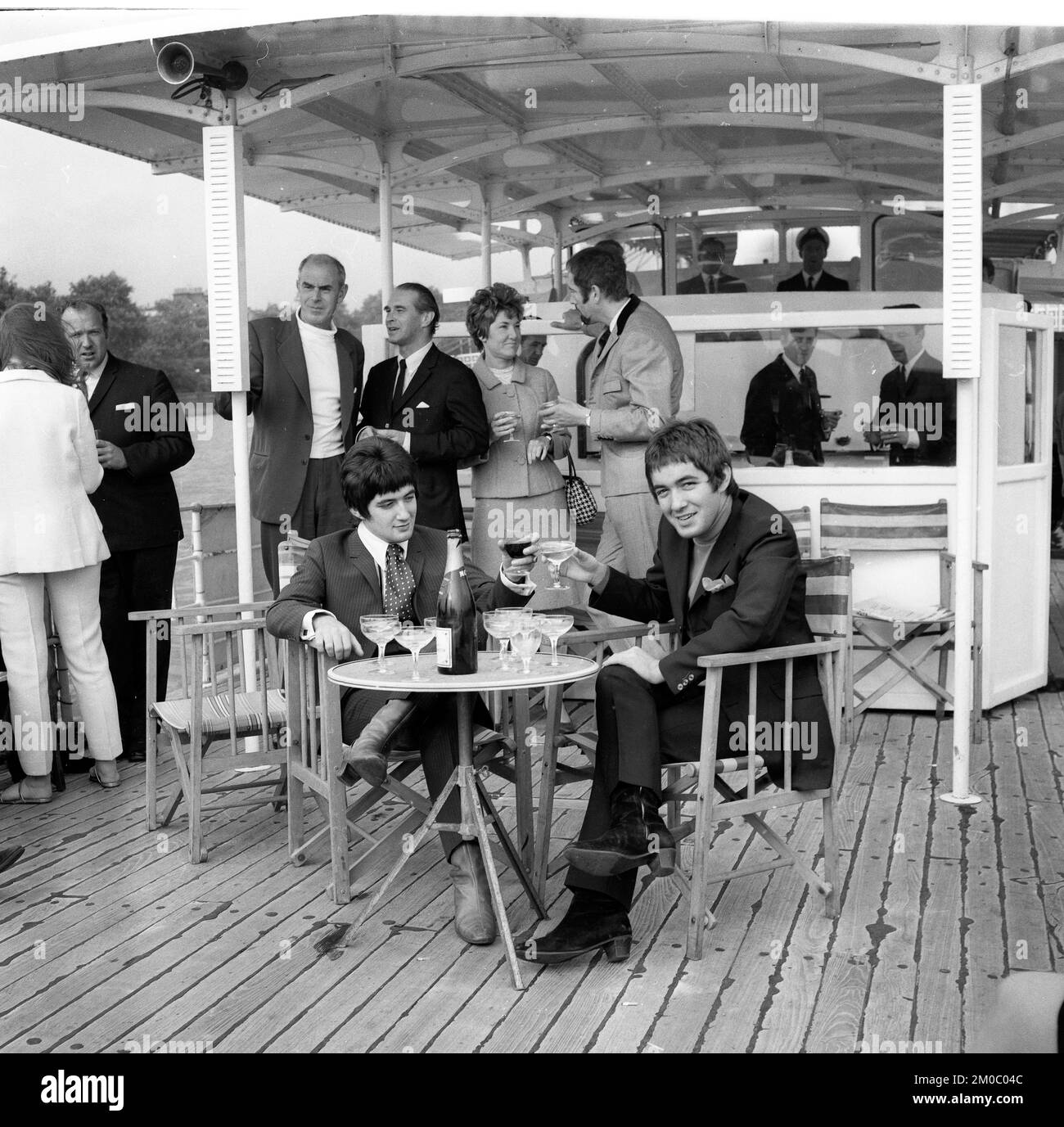 Le star pop Paul e Barry Ryan bevono champagne su una barca per feste sul Tamigi a Londra nel 1967 Foto Stock