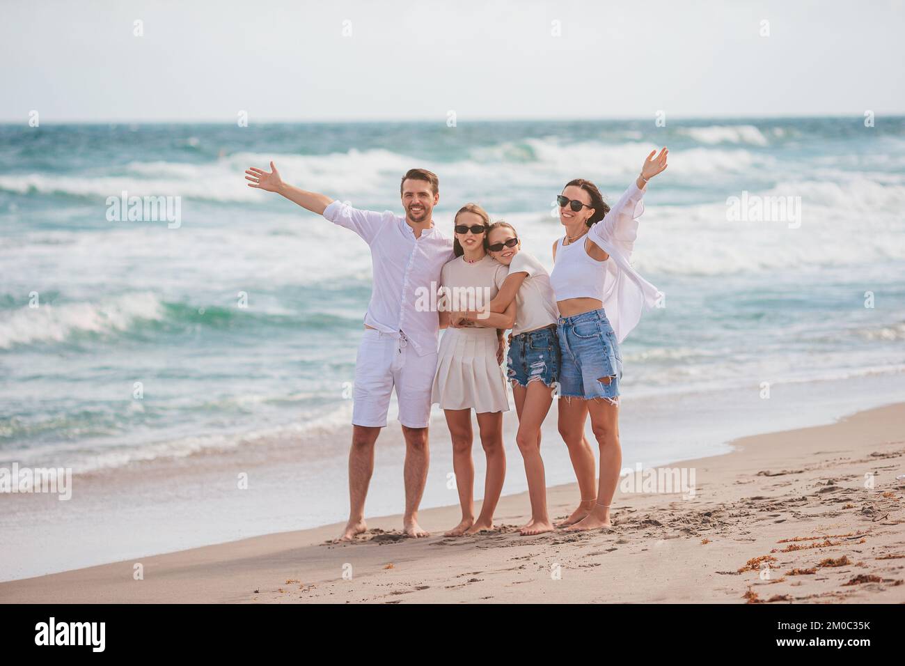 La famiglia felice sulla spiaggia durante le vacanze estive Foto Stock