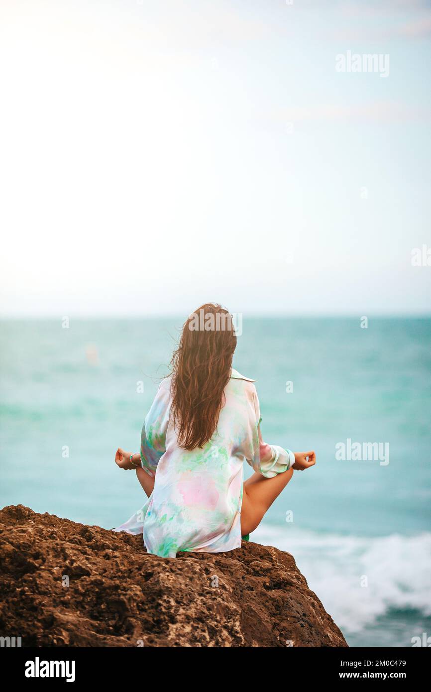 Giovane donna con yoga in spiaggia Foto Stock