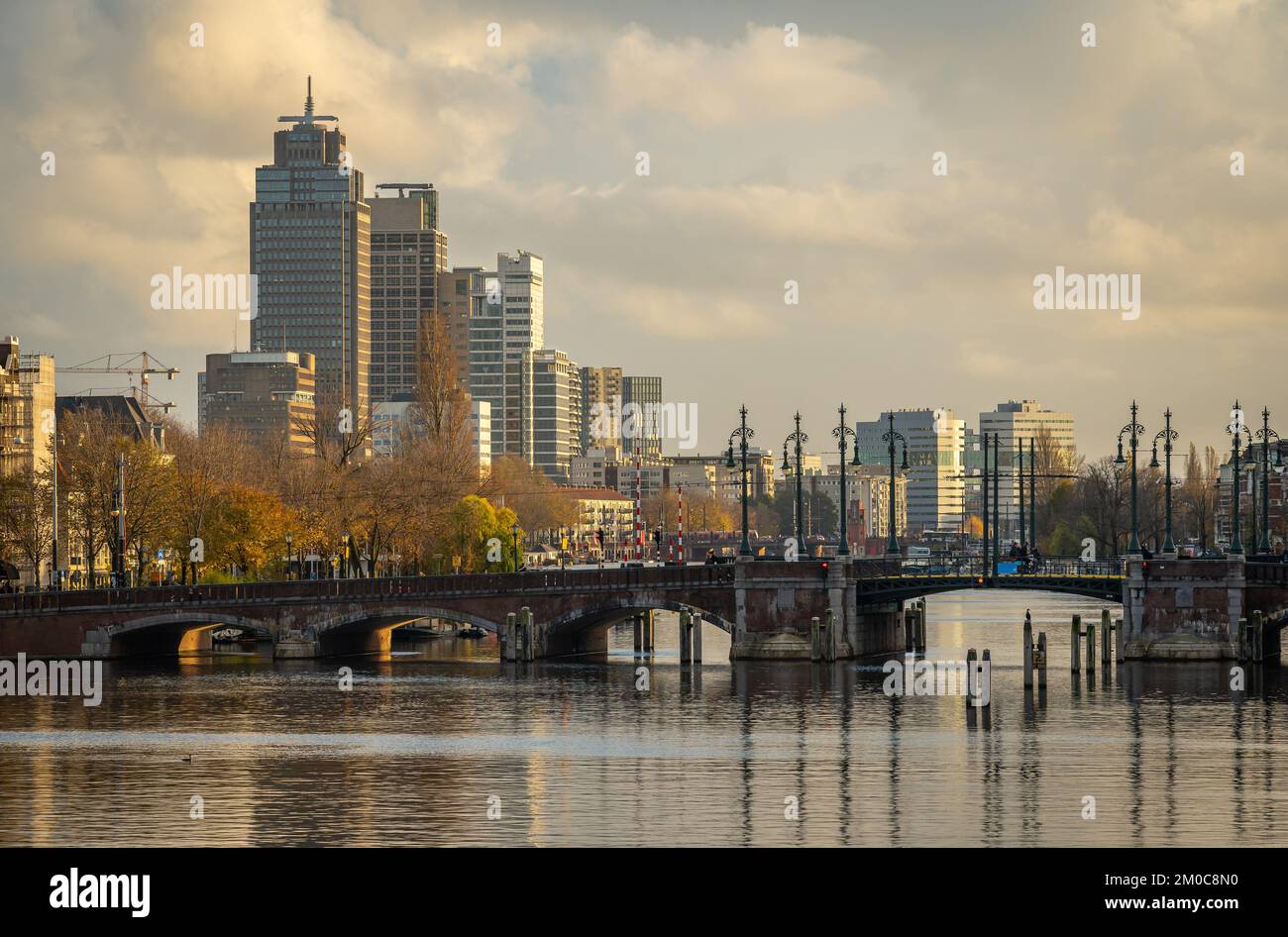 Skyline di Amsterdam con il fiume Amstel in primo piano e moderni alti edifici di uffici nel quartiere di Omval Foto Stock