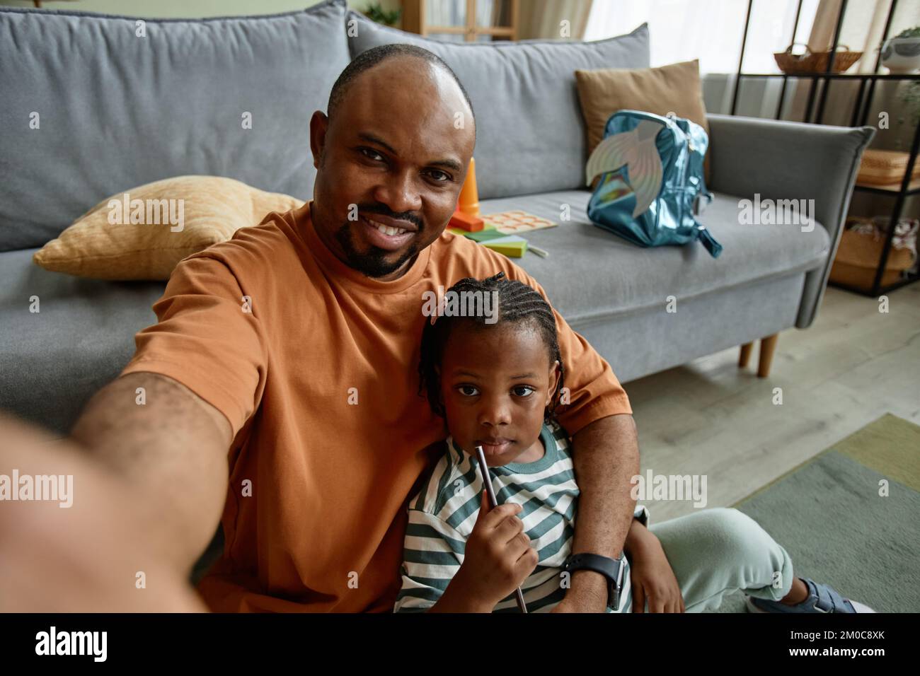 Ritratto ad angolo alto di padre amorevole scattare foto selfie con figlia carina in casa impostazione, copia spazio Foto Stock