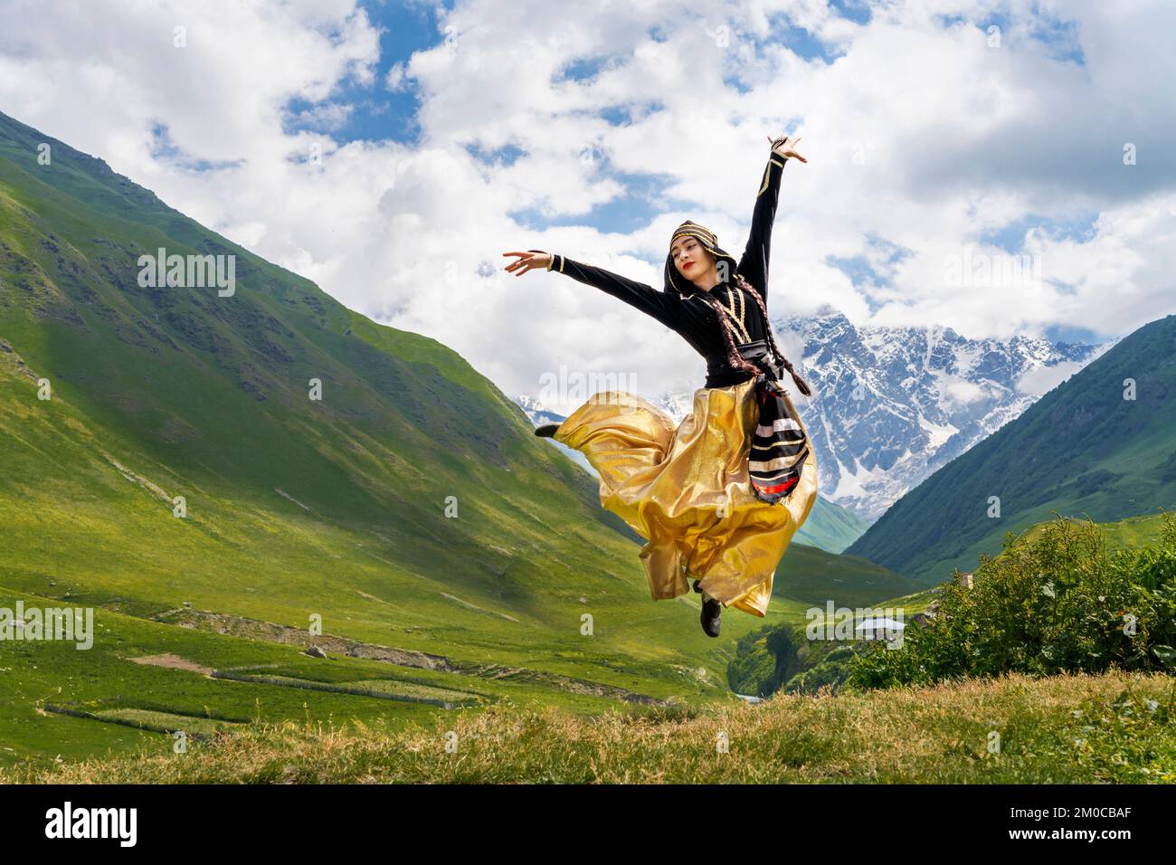 Donna georgiana in costumi locali Svaneti saltando e eseguendo danza tradizionale, a Ushguli, Georgia Foto Stock