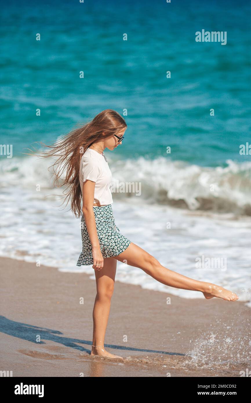 Adorabile ragazza adolescente divertirsi alla spiaggia tropicale durante le vacanze in acque poco profonde Foto Stock