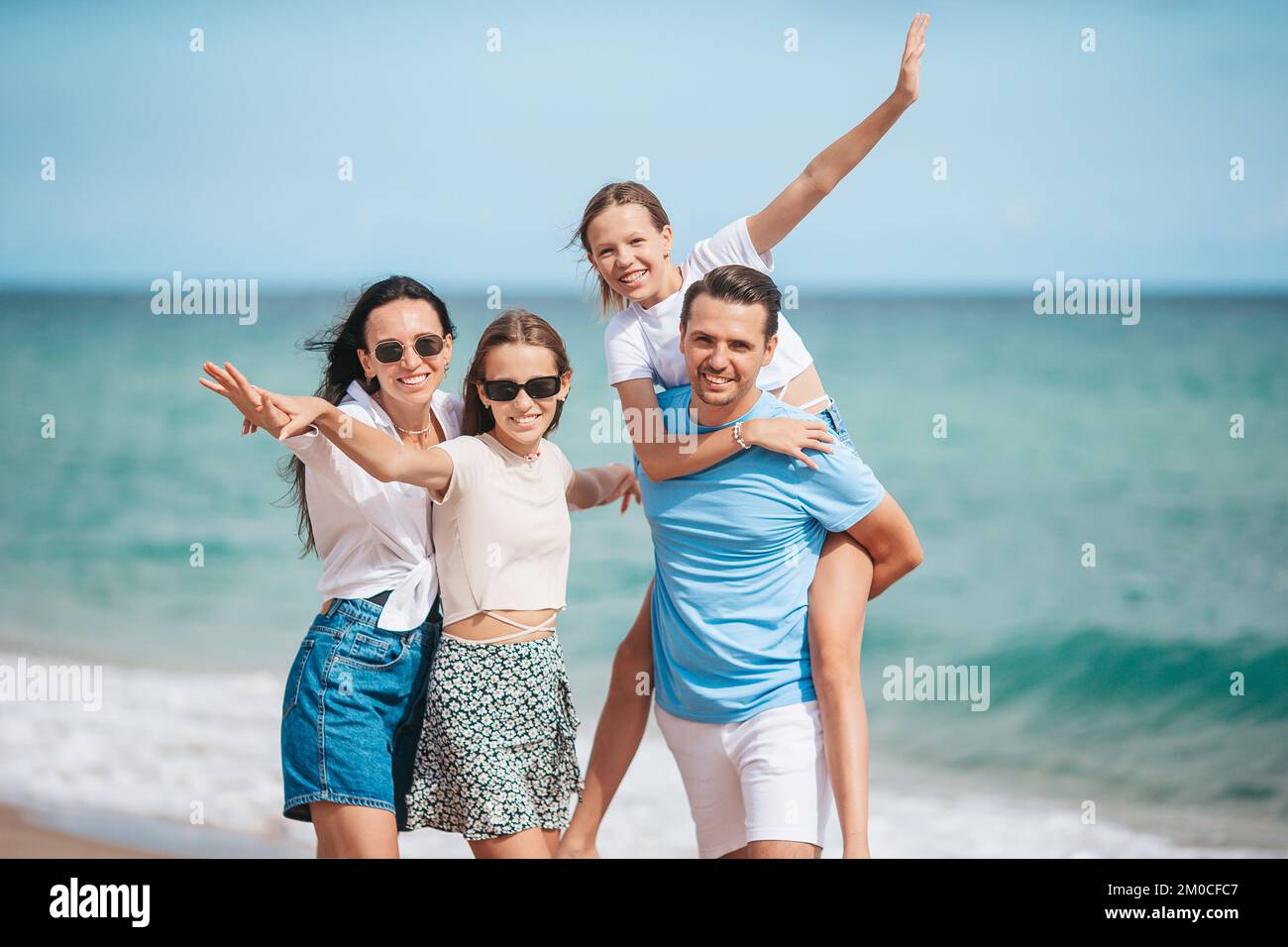La famiglia felice sulla spiaggia durante le vacanze estive Foto Stock