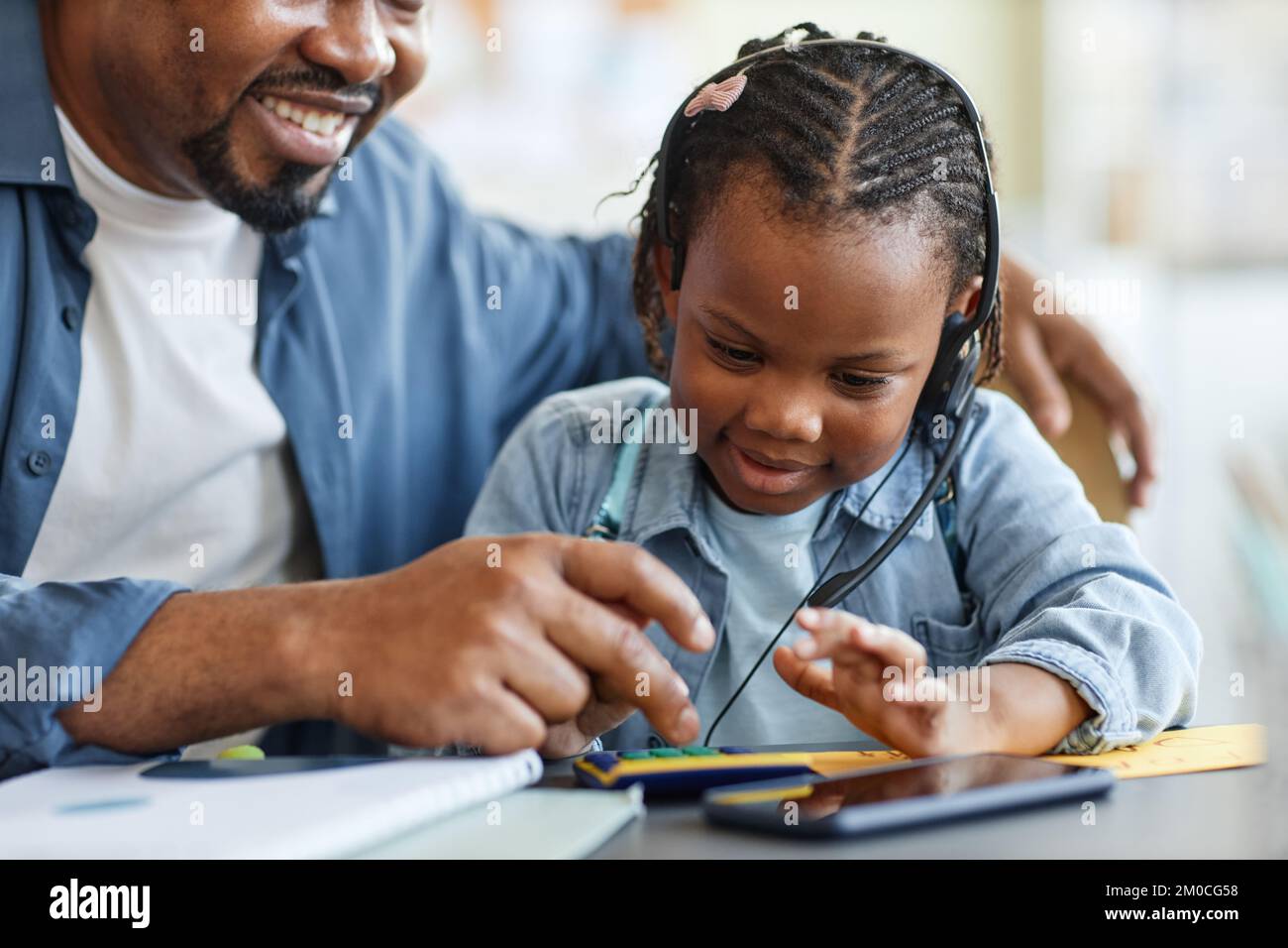 Ritratto della cura di padre e bambino che giocano con la calcolatrice giocattolo imparando a contare insieme Foto Stock