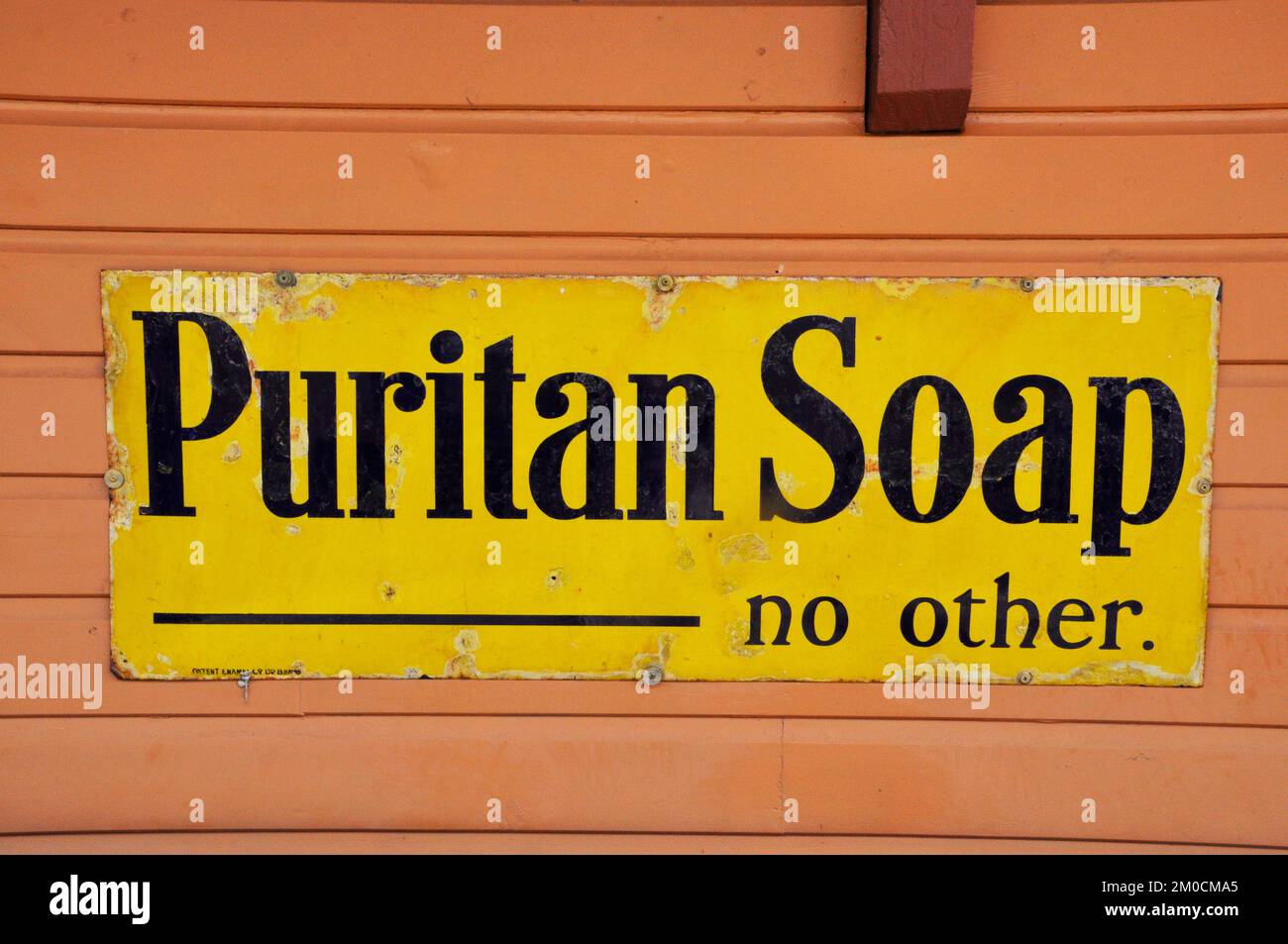 Enamelled metallo segno, pubblicità Puritan sapone fotografato alla stazione di Bishops Lydeard sulla ferrovia del Somerset ad ovest in Somerset, Inghilterra, Regno Unito Foto Stock