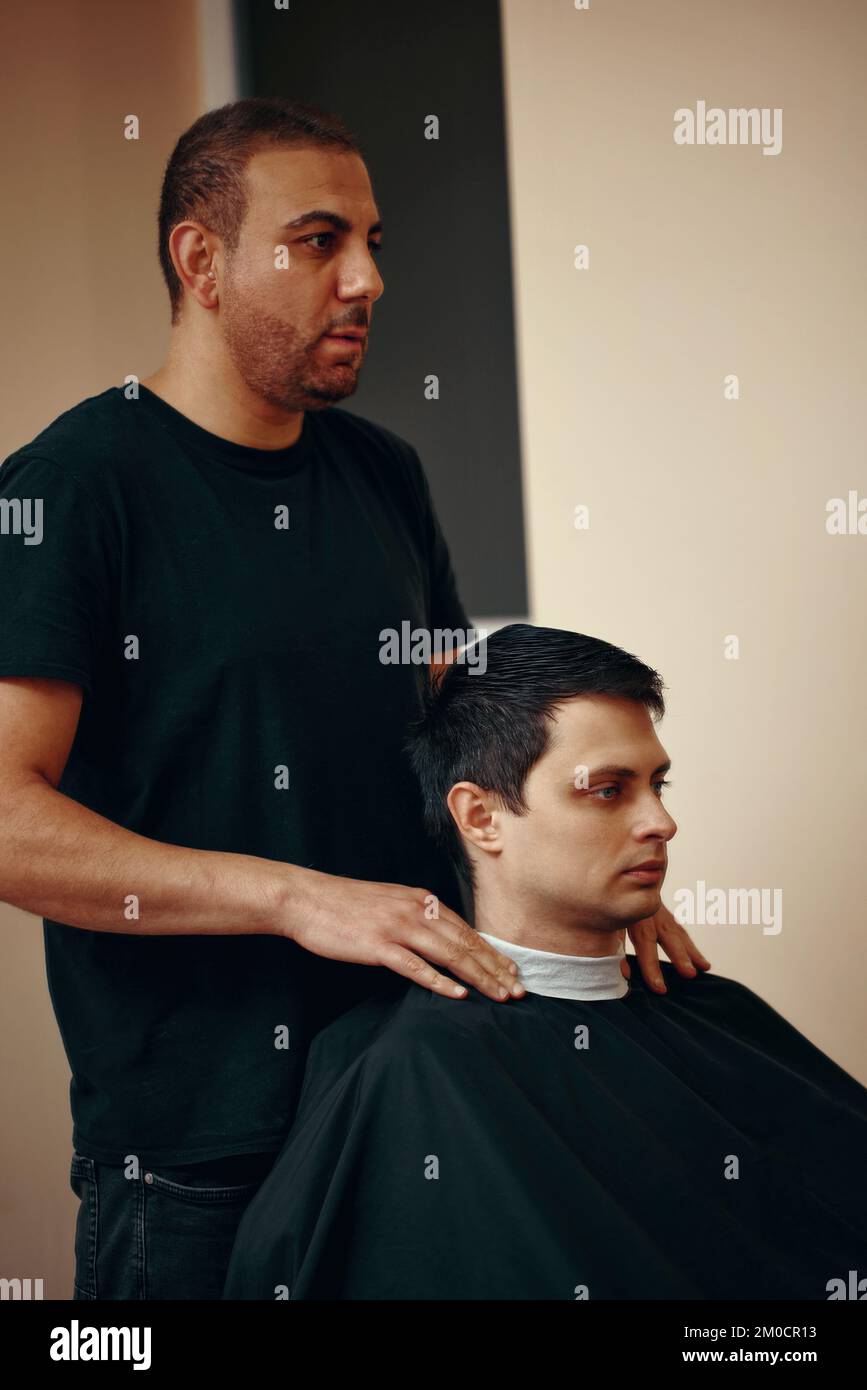 Barbiere e uomo beared soddisfatto davanti allo specchio Foto Stock