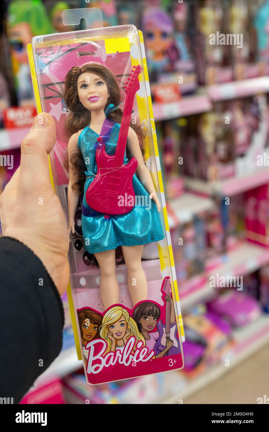 Barbie nella mano di un cliente in un negozio di giocattoli. Barbie è una bambola di moda prodotta dalla compagnia americana Mattel, Inc Foto Stock