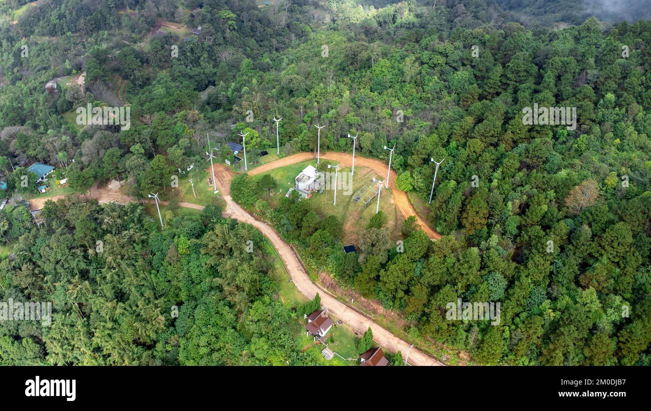 Vista aerea dal drone della strada di montagna con sole splendente nella foresta. Vista dall'alto di una strada su una collina in una splendida foresta verde in Thailandia. Naturale Foto Stock
