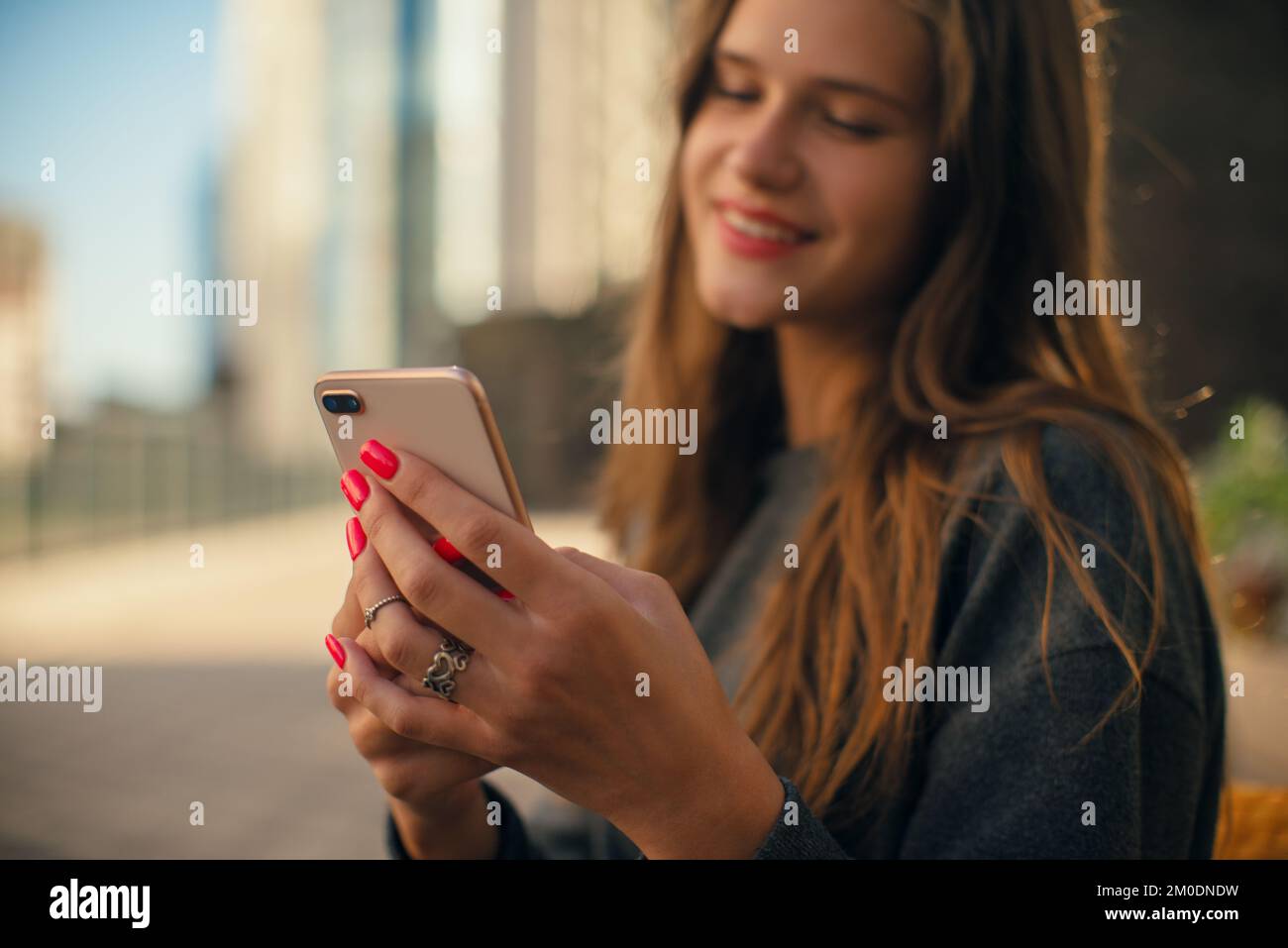 Giovane donna sorridente generazione Z che usa il cellulare da vicino Foto Stock