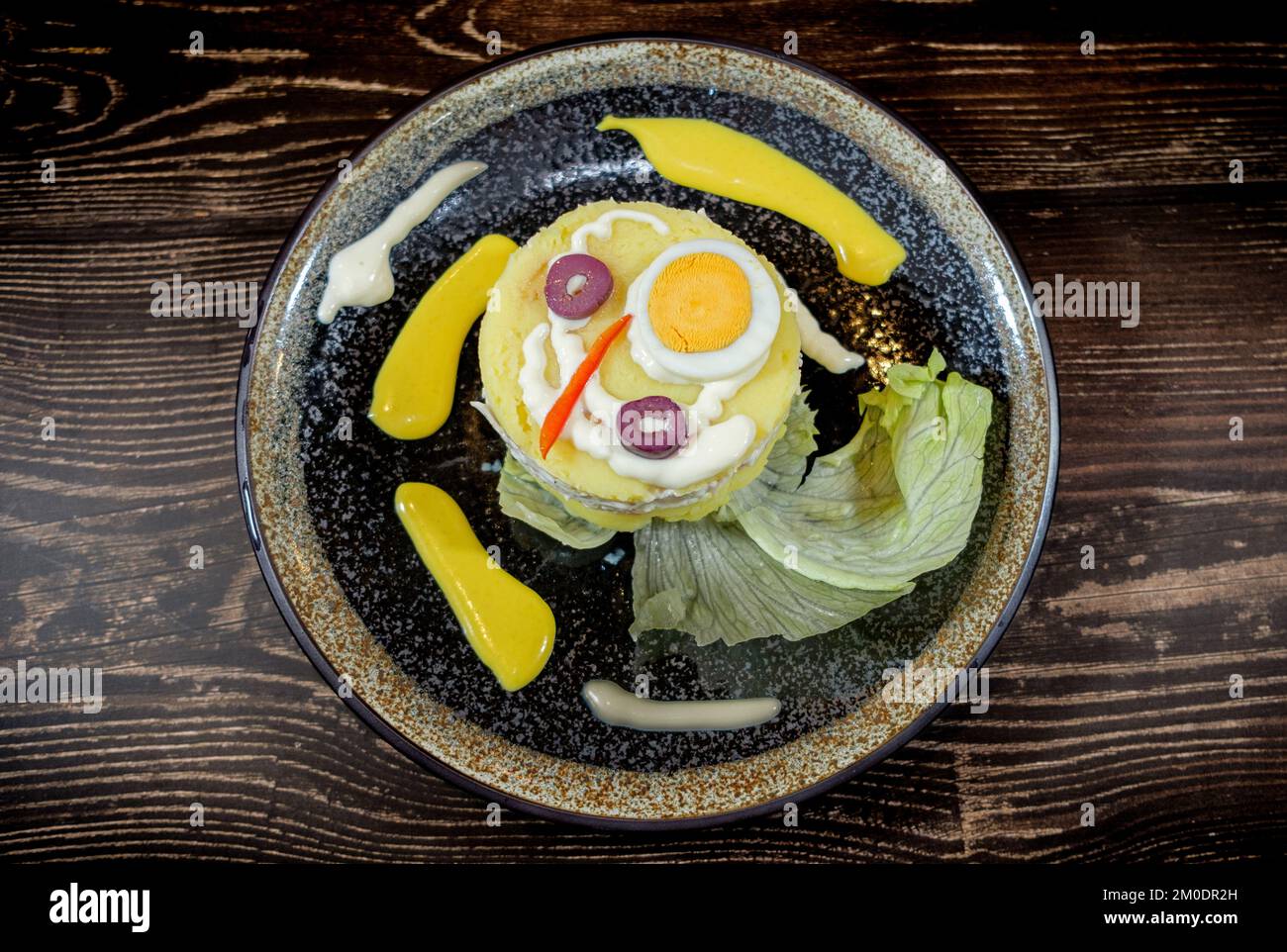 cause di pollo con peperoncino, lattuga e olive servite su tavola di legno Foto Stock