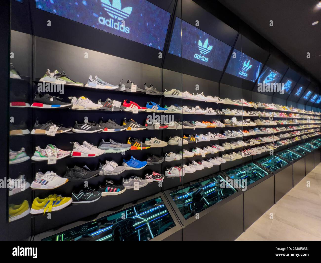 Vista diagonale delle sneakers dei marchi sportivi posizionate ordinatamente sugli scaffali per un'esperienza piacevole per i clienti. Singapore. Foto Stock