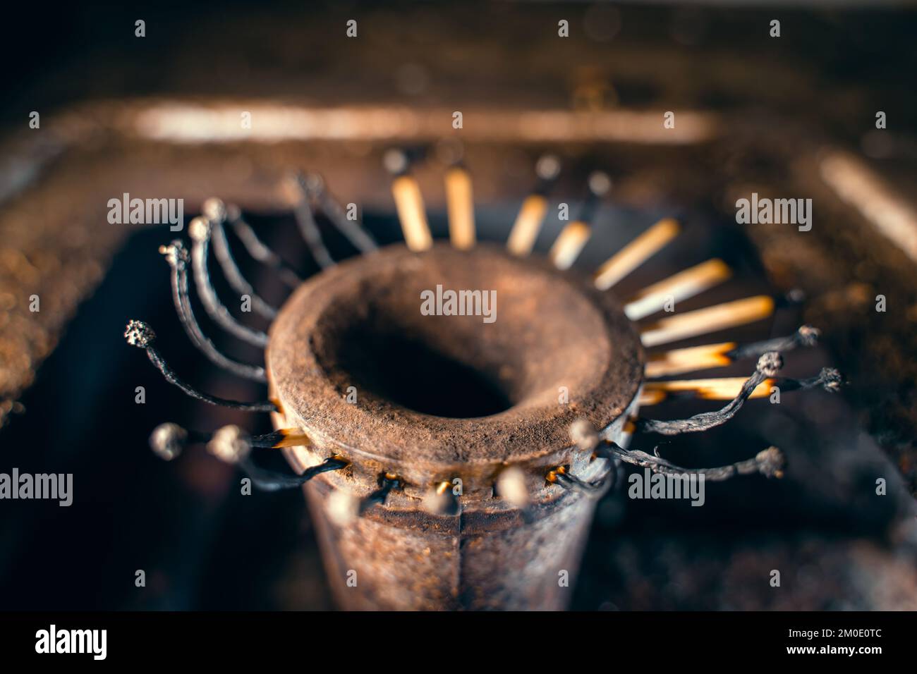 Fiammiferi di legno bruciati invece di fuoco nel bruciatore di una stufa a gas close-up. Basso tenore di vita, sopravvivenza in condizioni di povertà. Risparmio di gas naturale. S Foto Stock