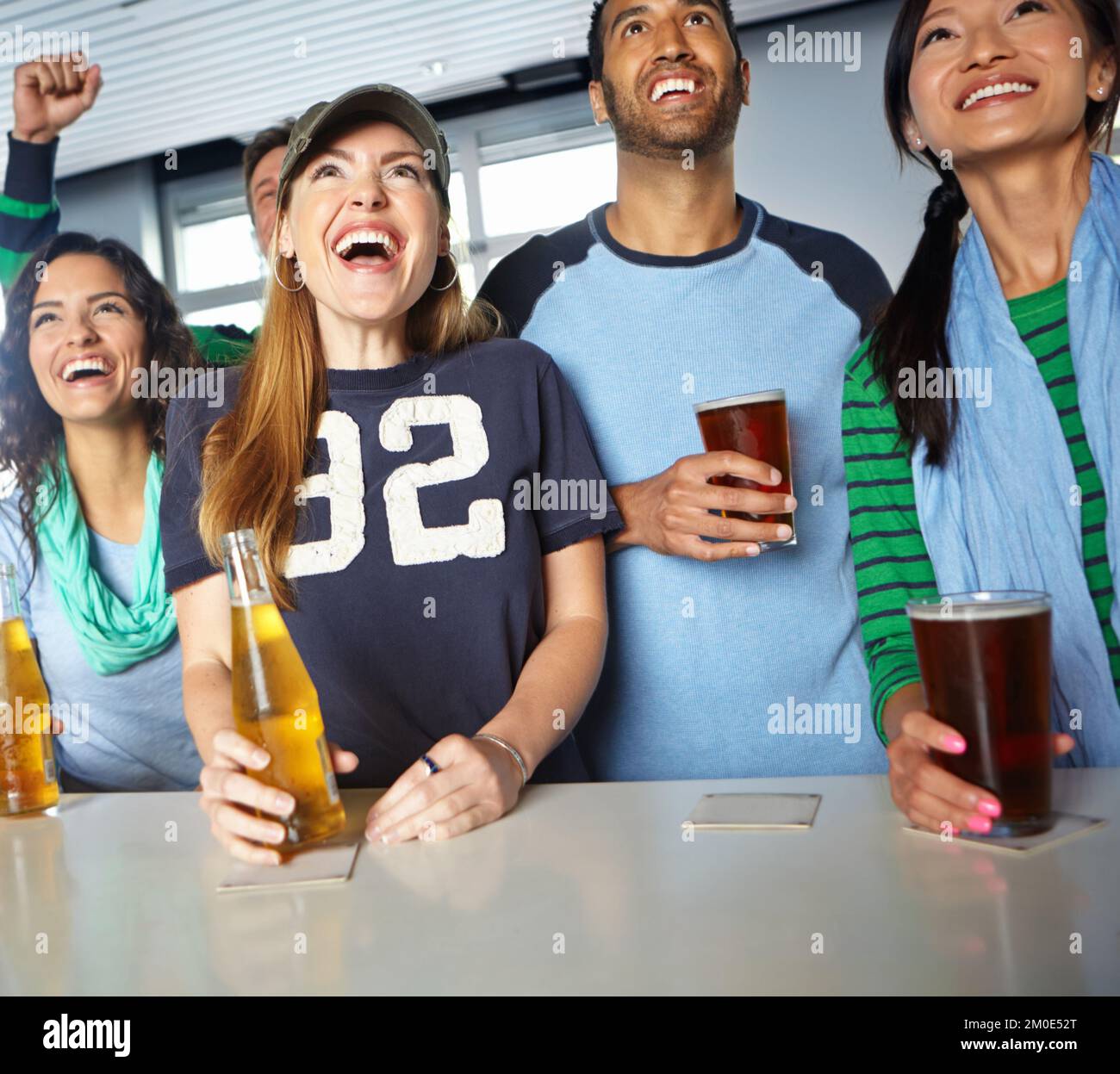 Dai. Un gruppo di amici che allietano la loro squadra di sport preferita al bar. Foto Stock