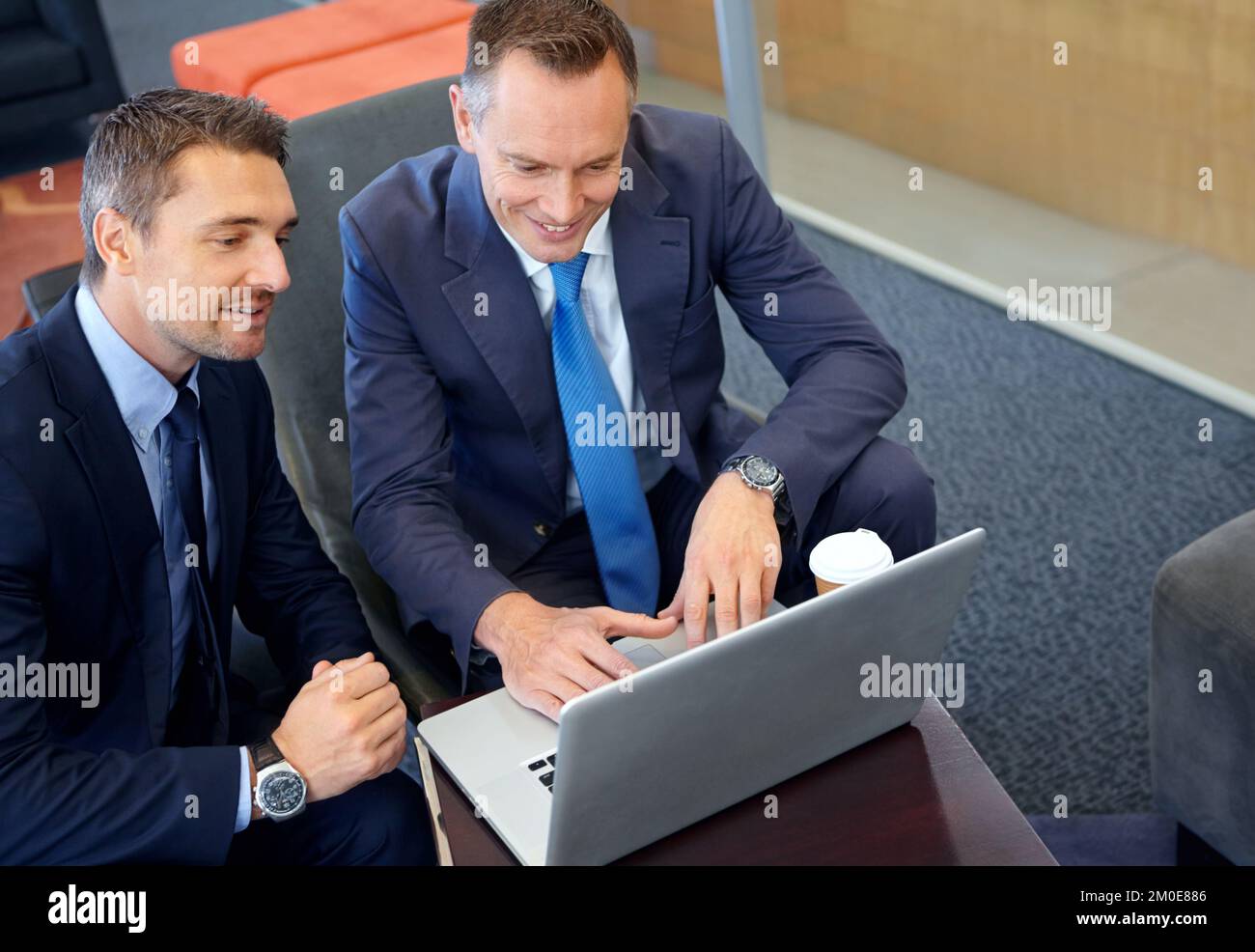 Discutere di possibili opzioni di investimento. Due uomini d'affari maturi che lavorano insieme mentre condividono un notebook. Foto Stock