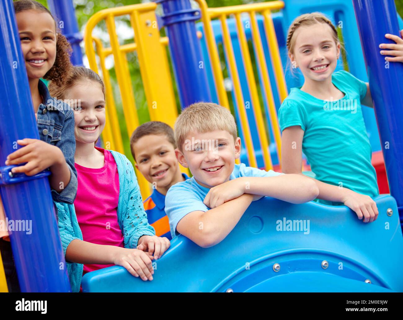 Theyre un gruppo di amici a maglia stretta. Un gruppo multietnico di bambini felici che giocano in una palestra nella giungla in un parco giochi. Foto Stock