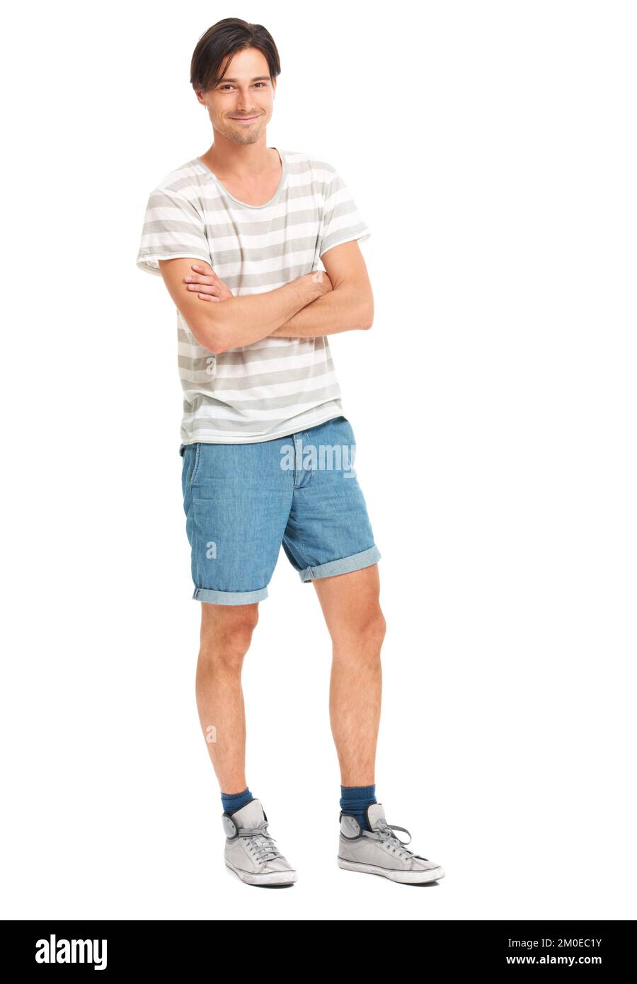 Un uomo modesto. Un giovane uomo a tutta lunghezza sorridente timidamente alla telecamera, isolato su bianco - copyspace. Foto Stock