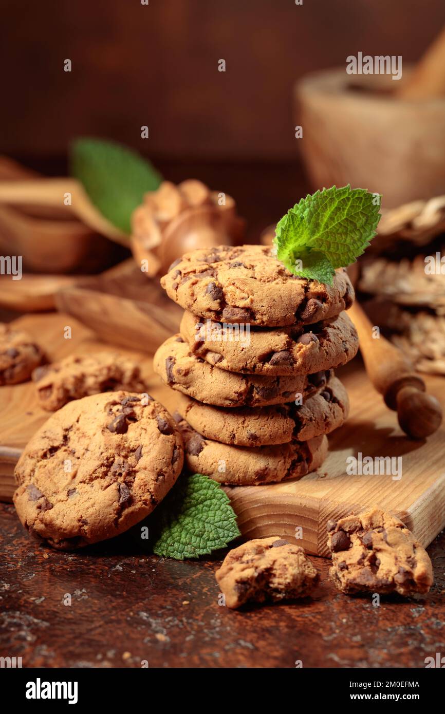 Biscotti al cioccolato appena sfornati con menta su sfondo marrone. Foto Stock
