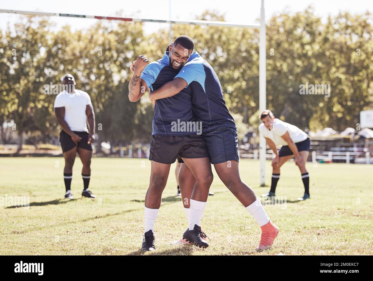 Due compagni di rugby afroamericani festeggiano la possibilità di provare o vincere una partita all'aperto su un campo sportivo. I giocatori di rugby allietano durante una partita Foto Stock