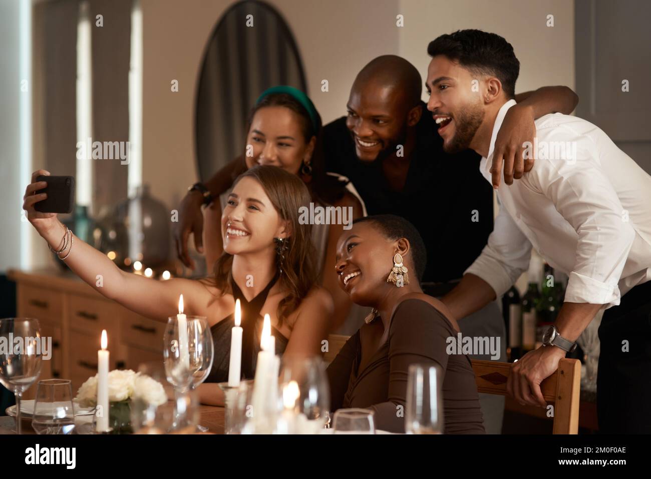 Amici alla festa, selfie e cena con telefono per fotografare, sorridere e felice insieme per festeggiare il nuovo anno. Cena, festeggia le feste e. Foto Stock