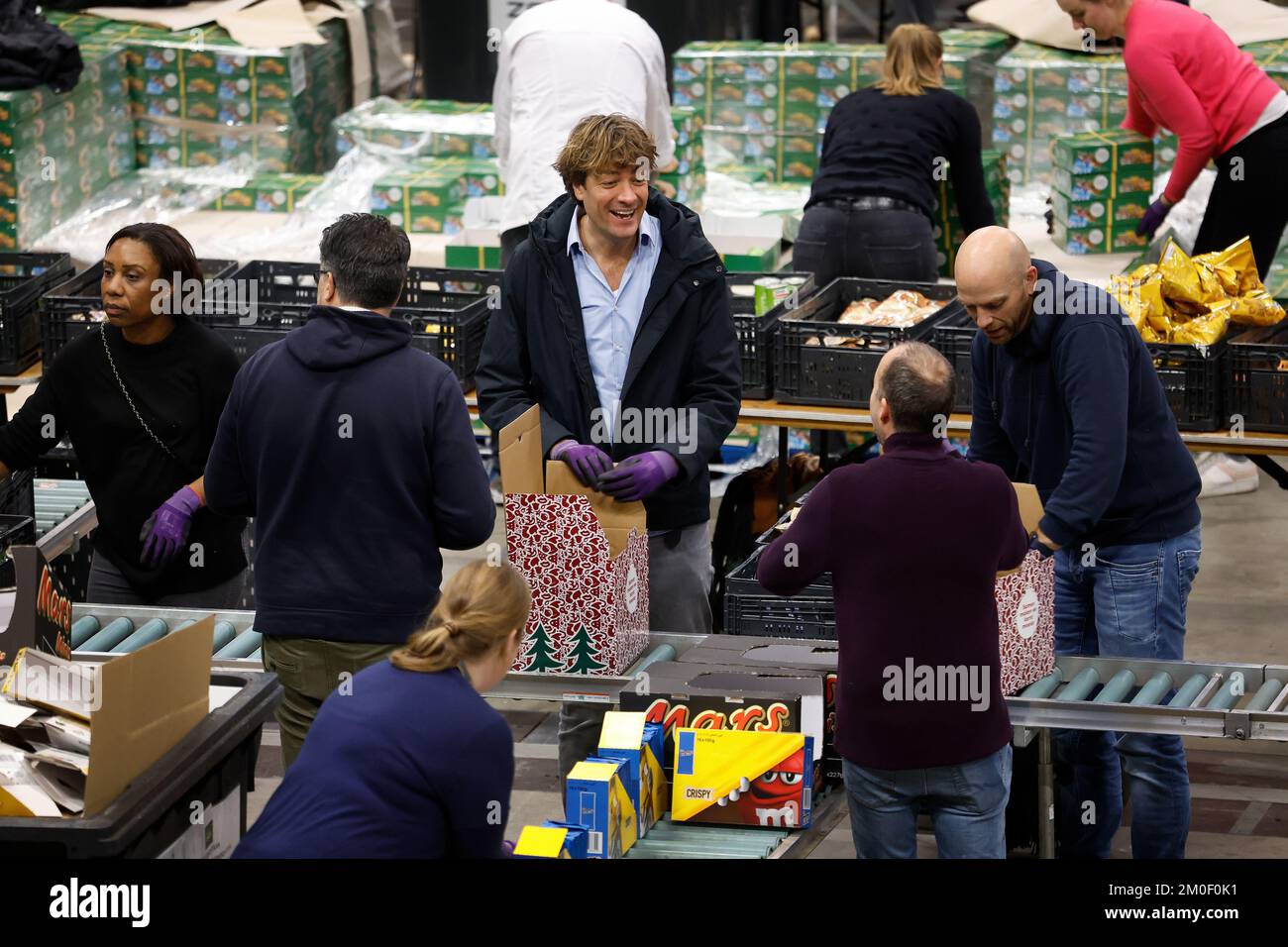 ROTTERDAM - Ambasciatore della Food Bank Frank Dane (M) e volontari confezionare pacchetti di Natale per le banche alimentari nei Paesi Bassi. Quest'anno, un record di 45.000 cetrioli natalizi saranno imballati per le famiglie dipendenti dalla banca alimentare. ANP BAS CZERWINSKI olanda fuori - belgio fuori Foto Stock