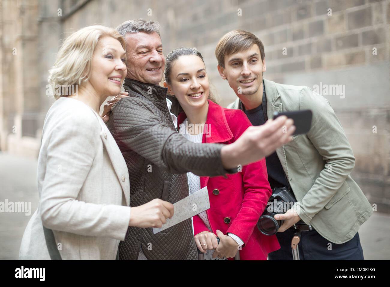 Turisti che prendono selfie sulla vecchia strada della città europea Foto Stock