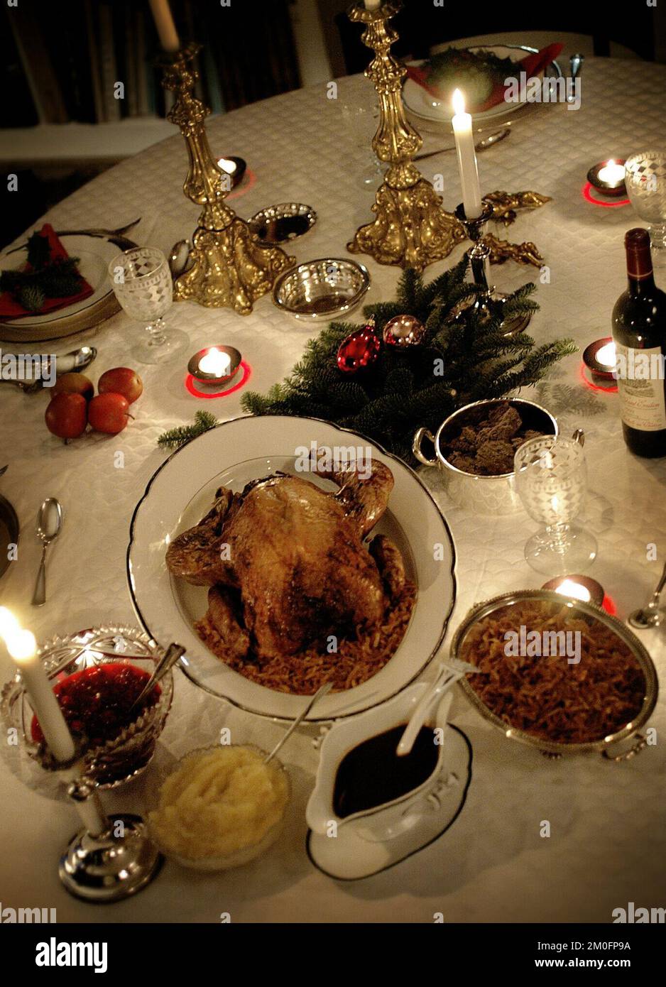 Tradizioni natalizie in Danimarca. Un tavolo da pranzo con decorazioni e candele. Una tradizionale cena di Natale danese è un'anatra, oca o arrosto servito con vino. Foto Stock