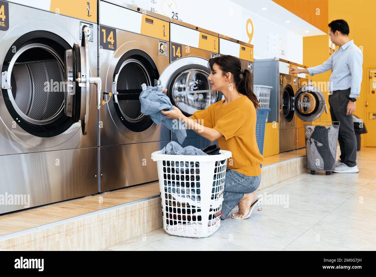 Persone asiatiche che utilizzano una macchina da lavanderia a gettoni  qualificata nella sala pubblica per lavare i loro panni. Concetto di una  lavanderia commerciale self-service e Foto stock - Alamy