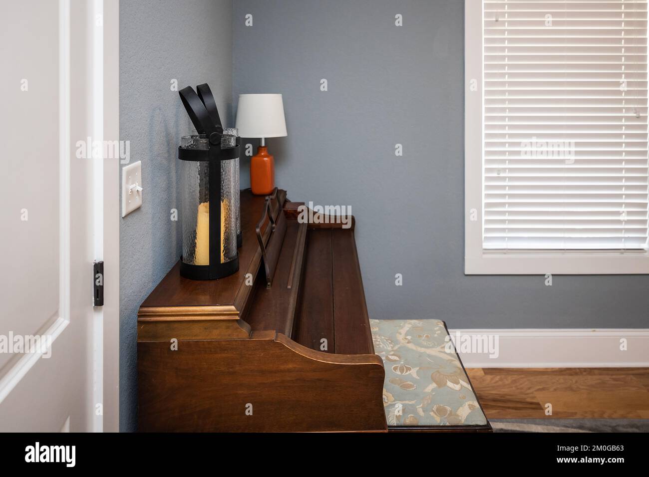 Home music room per studenti con pianoforte in legno e pareti blu grigie Foto Stock