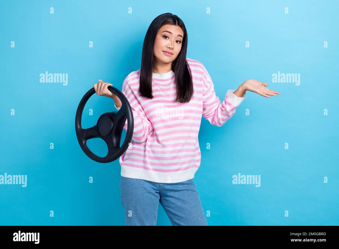 Foto di giovane insoddisfatto tassista coreano donna indossare a strisce jumper shrug spalle nessuna idea dove nuova auto isolato su sfondo di colore blu Foto Stock