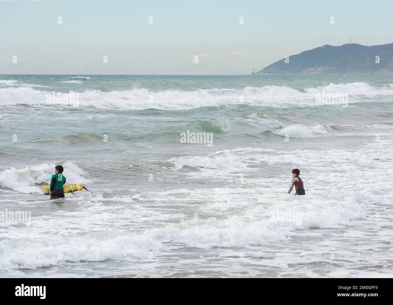 Castelldefels, Barcellona, Spagna - 9 gennaio 2016: Due amici tra i dieci e gli undici anni con le loro tavole da surf godendo di una nuvolosa giornata invernale, lo Foto Stock