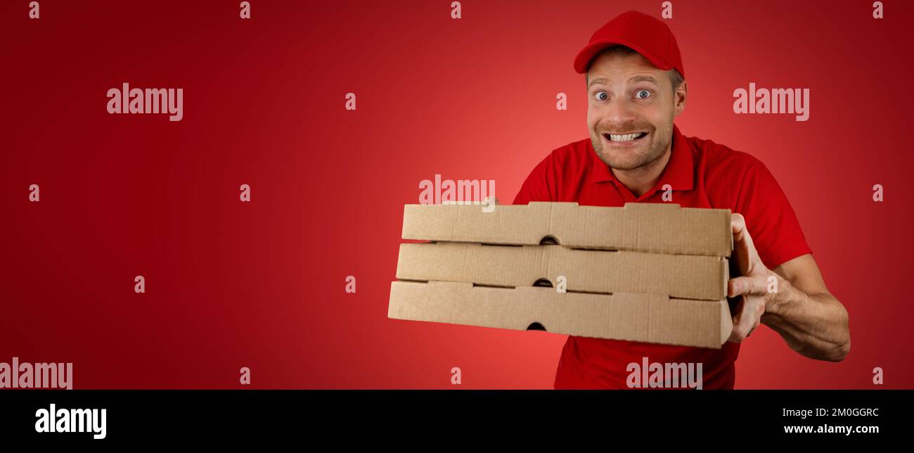 divertente uomo con scatole di pizza su sfondo rosso. banner con spazio di copia Foto Stock