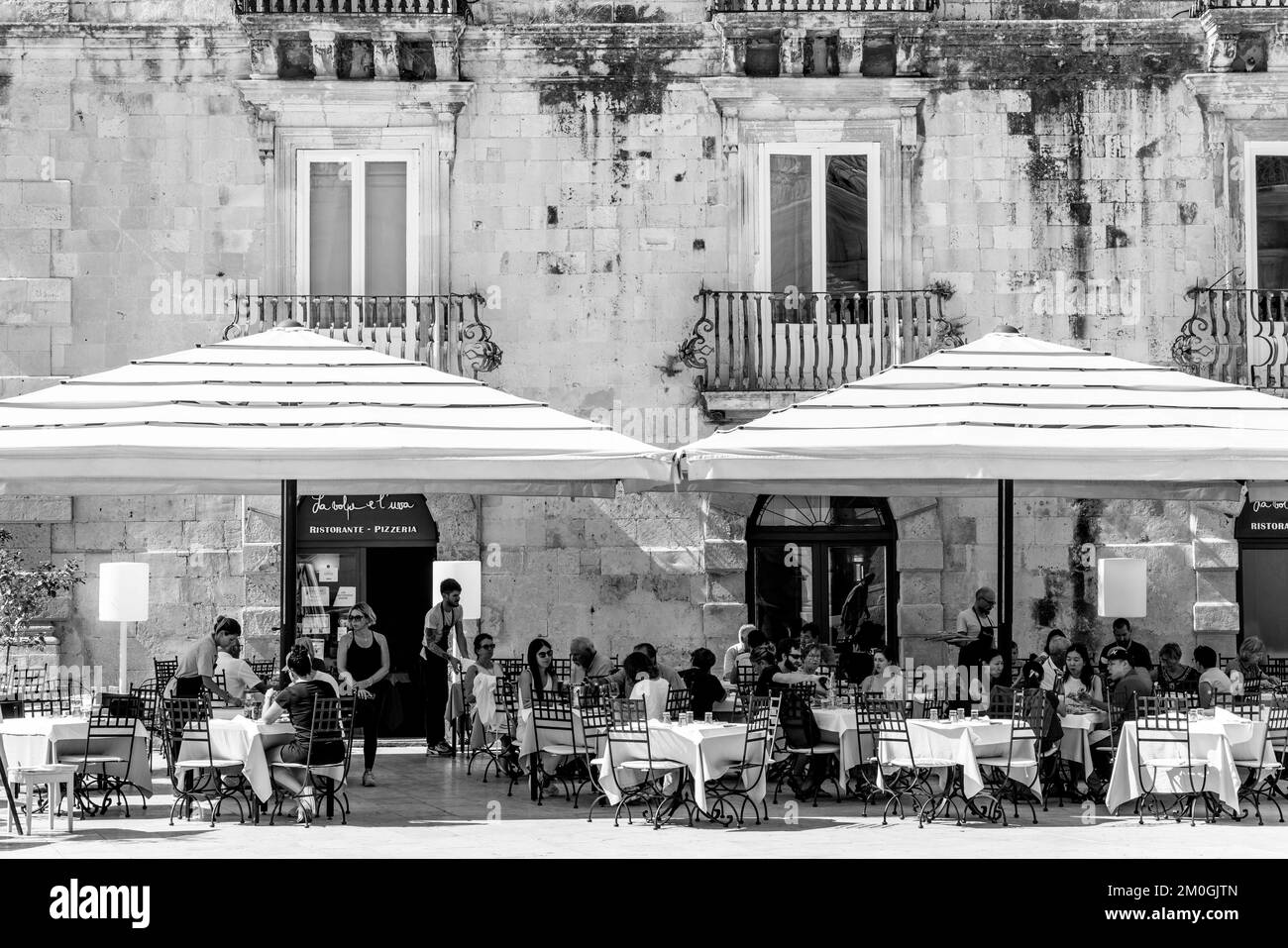 I clienti seduti fuori dal Ristorante la Volpe e l'uva, Piazza Duomo, Ortigia, Siracusa, Sicilia, Italia Foto Stock