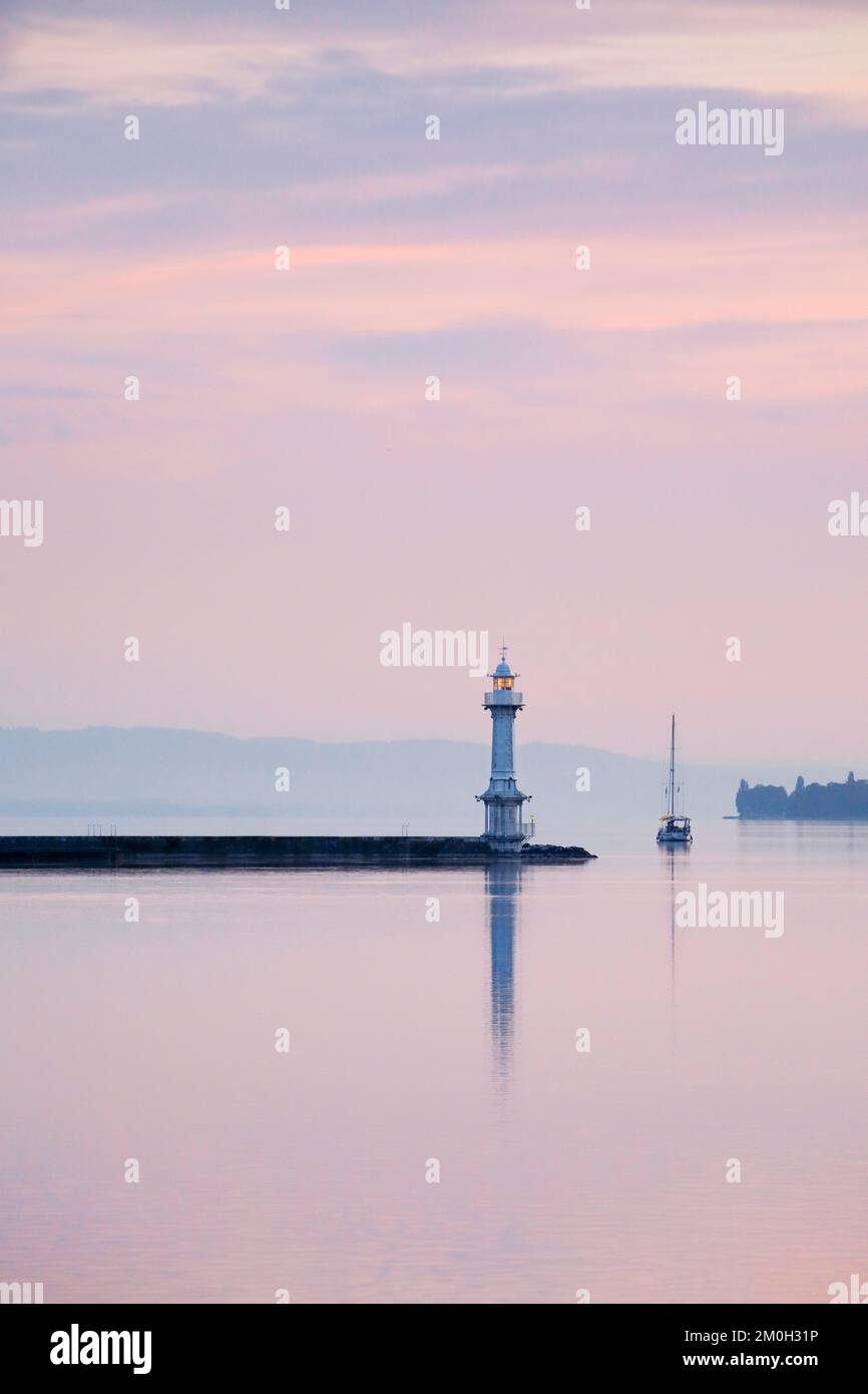 Faro vicino alla parete del porto nel bacino del Lago di Ginevra all'alba rosa, Canton Ginevra, Svizzera, Europa Foto Stock