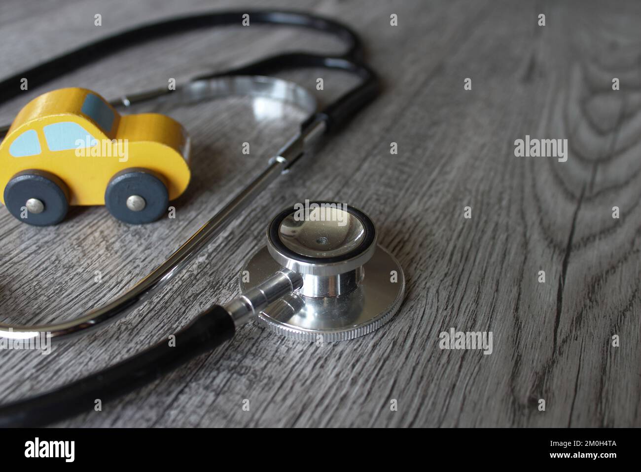 Macchina giocattolo e stetoscopio. Concetto di diagnostica, ispezione, riparazione e manutenzione per autoveicoli. Foto Stock