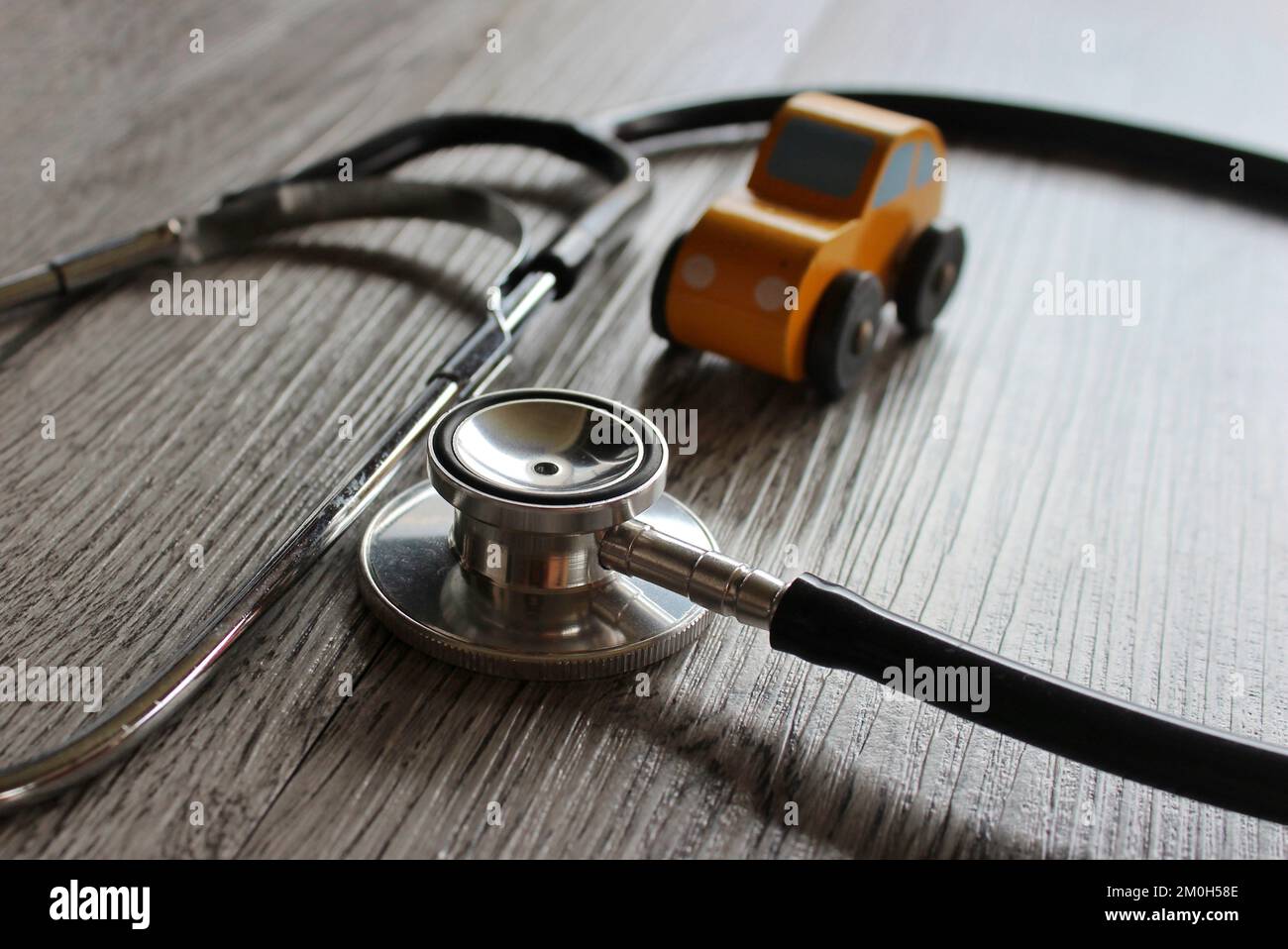 Macchina giocattolo e stetoscopio. Concetto di diagnostica, ispezione, riparazione e manutenzione per autoveicoli. Foto Stock