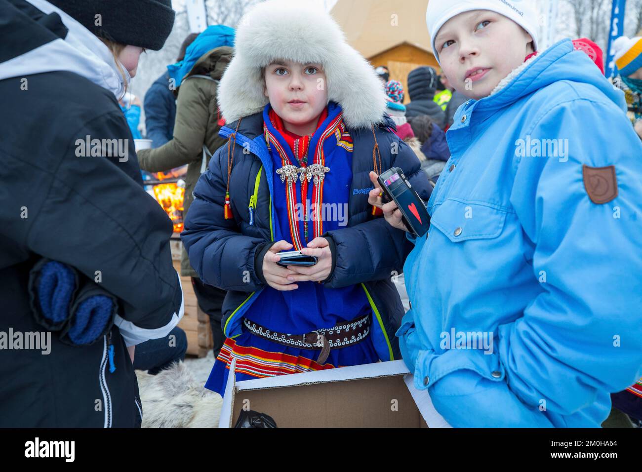 Svezia, Contea di Norbotten, Jokkmokk, giovane Sami al telefono, in costume tradizionale, durante il mercato Sami a Jokkmokk Foto Stock