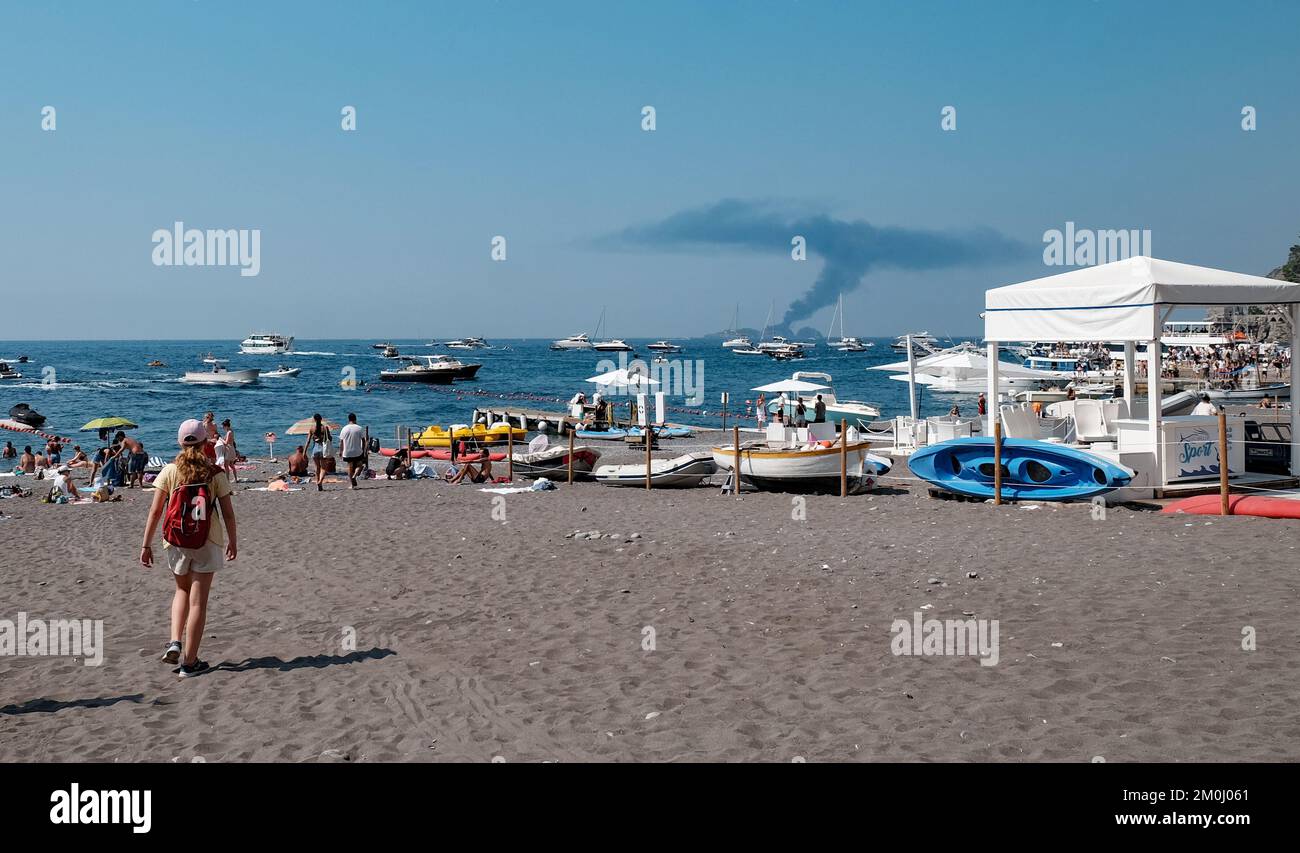 Che cosa sta accadendo qui? Un'immagine interessante mostra un'enorme nuvola di fumo dalla spiaggia di Positano come aspetto pubblico. E 'un motore yacht fuoco fuori per vedere. Foto Stock