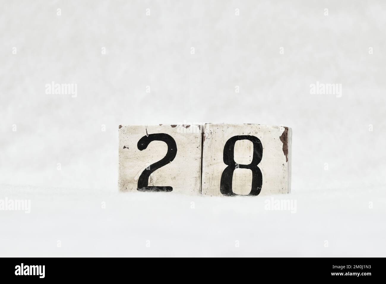 28 numero di calendario a blocchi di legno vintage su sfondo bianco neve, spazio di copia per il testo. Salvare la data per il compleanno, l'anniversario, il giorno speciale o l'occasione Foto Stock