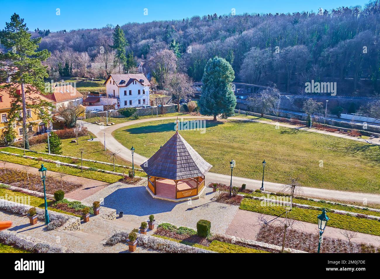 I bellissimi giardini verdi Breuer con alti pini, padiglione in legno, aiuole fiorite, ponte sul torrente Vrchlice e la foresta sullo sfondo, Kutna Hora, C Foto Stock