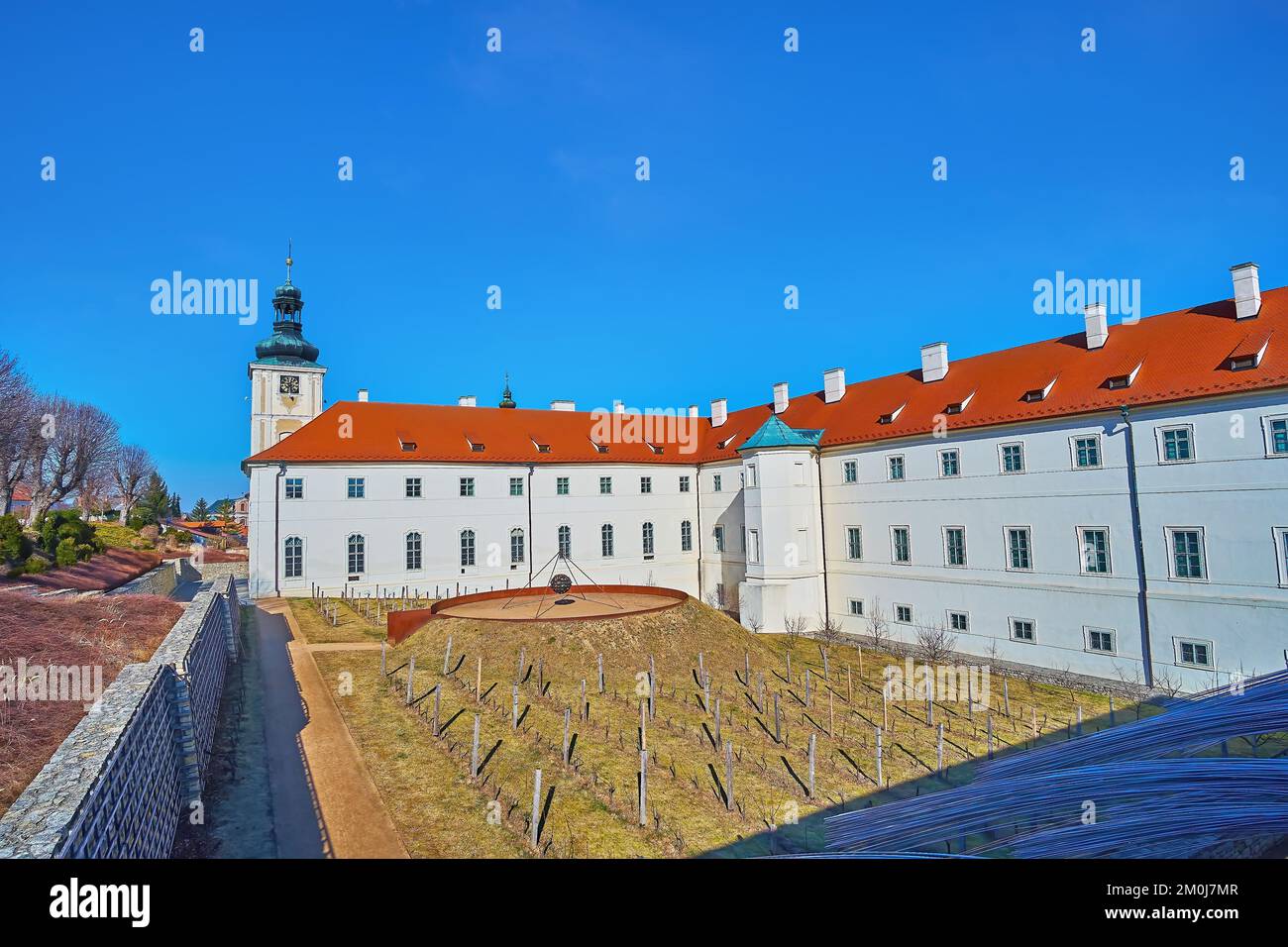 La piccola corte dell'ex Collegio dei Gesuiti con le vigne e la torre dell'orologio sullo sfondo, Kutna Hora, Repubblica Ceca Foto Stock