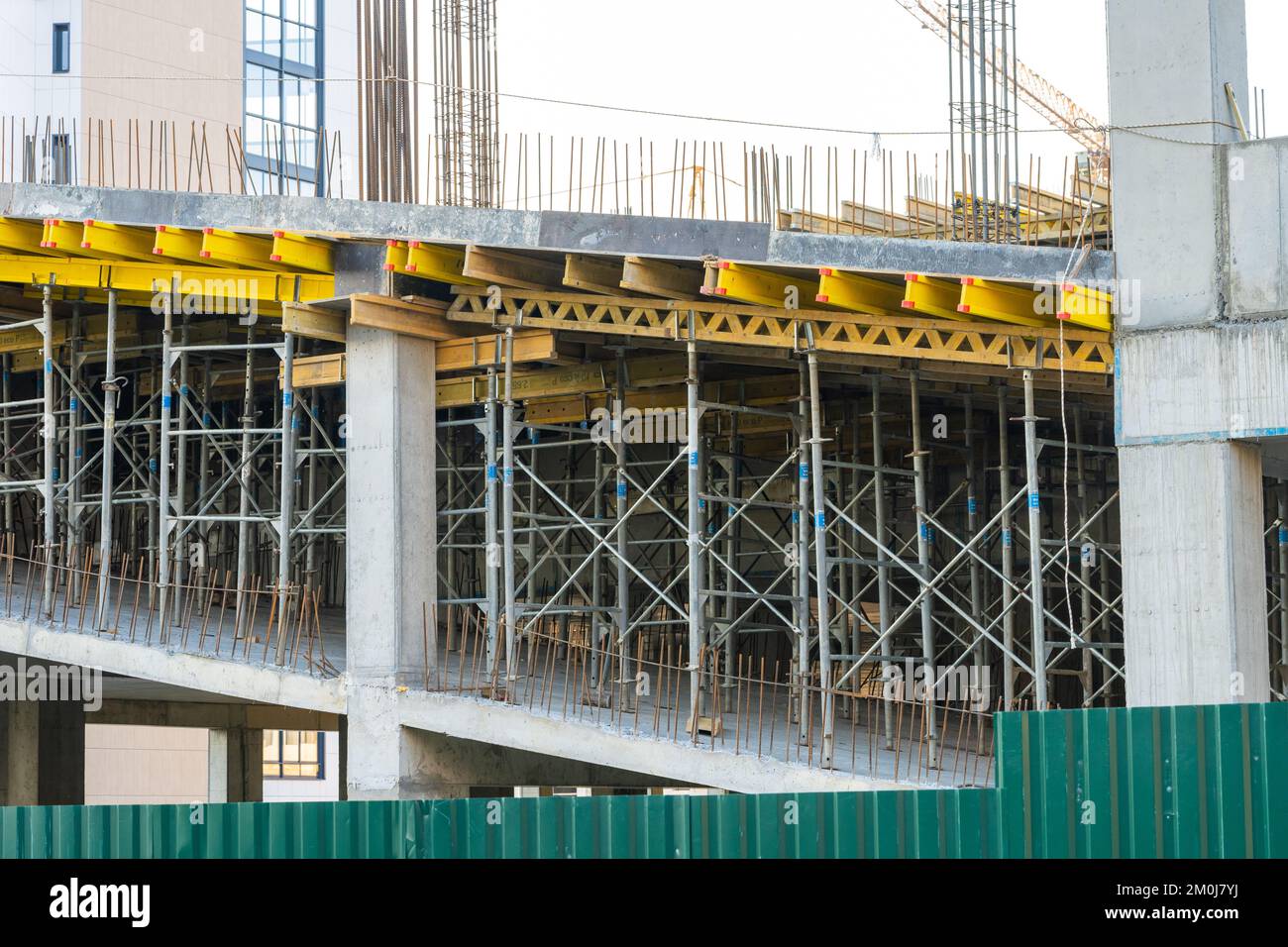 Cantiere con ponteggi monolitici in cemento giallo e grigio. Concetto di costruzione. Foto Stock